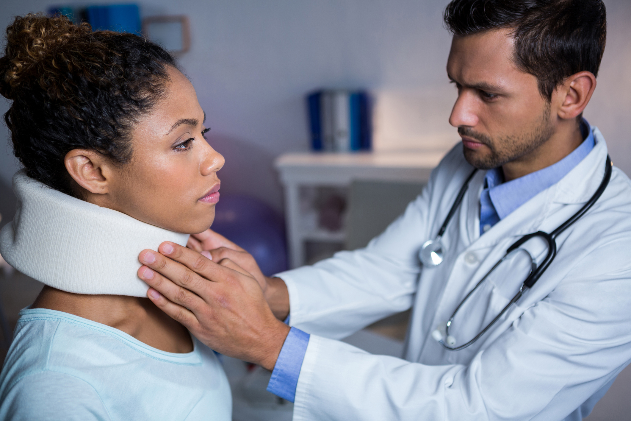 Physiotherapist examining a female patient's neck