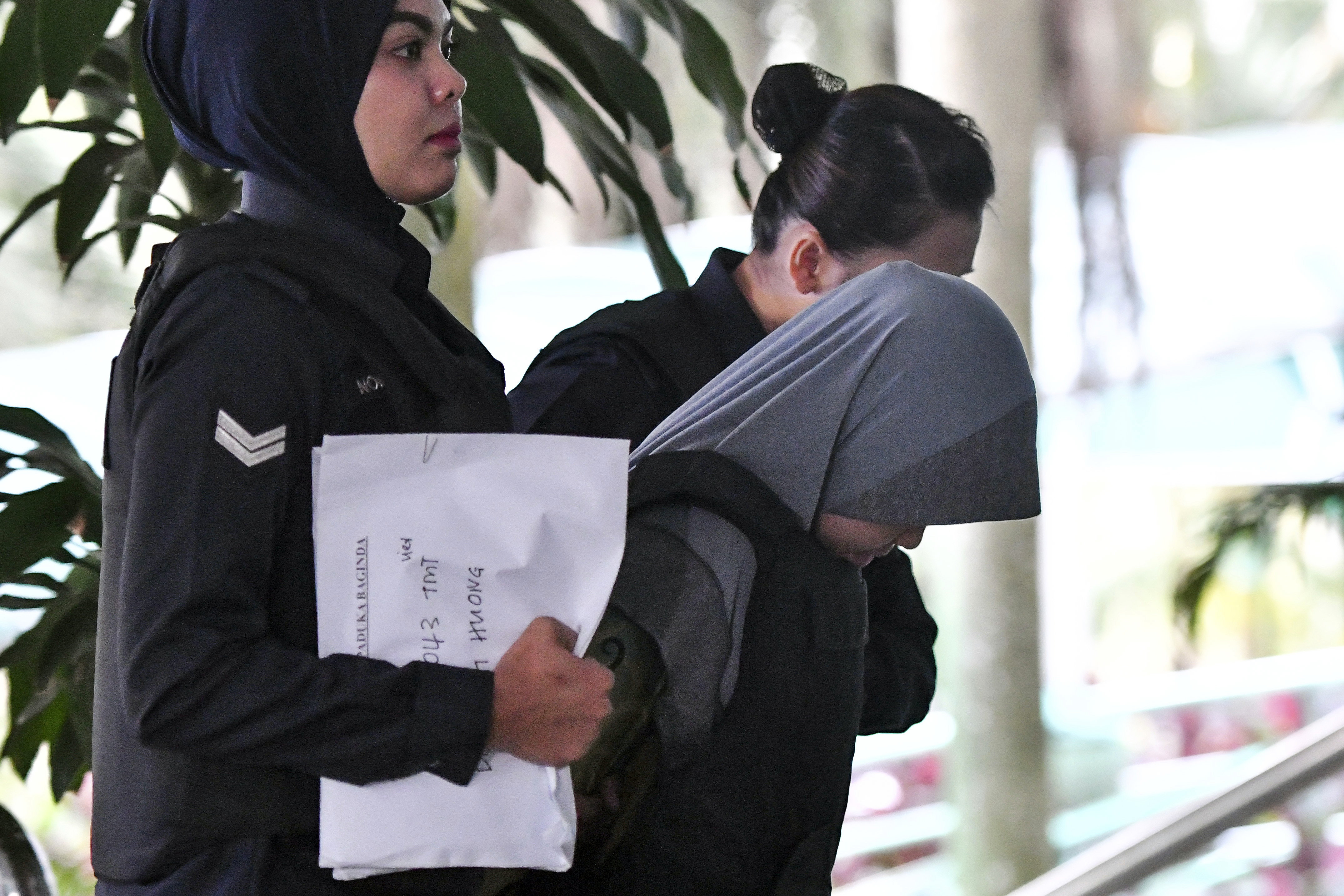 Siti Aisyah is escorted by police as she arrives at Shah Alam High Court in Malaysia