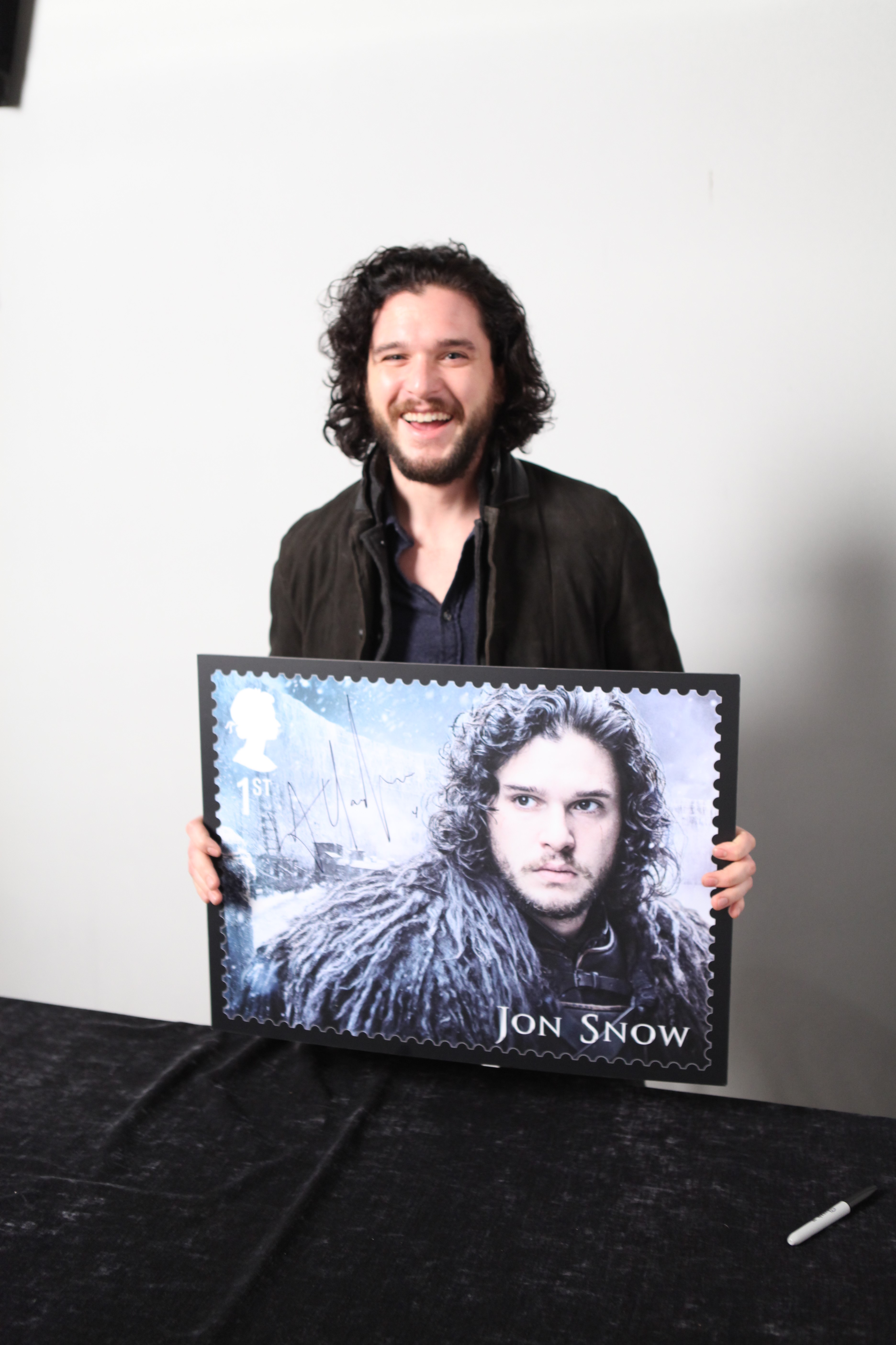 Kit Harington holding up the giant stamp which will be auctioned (Royal Mail)