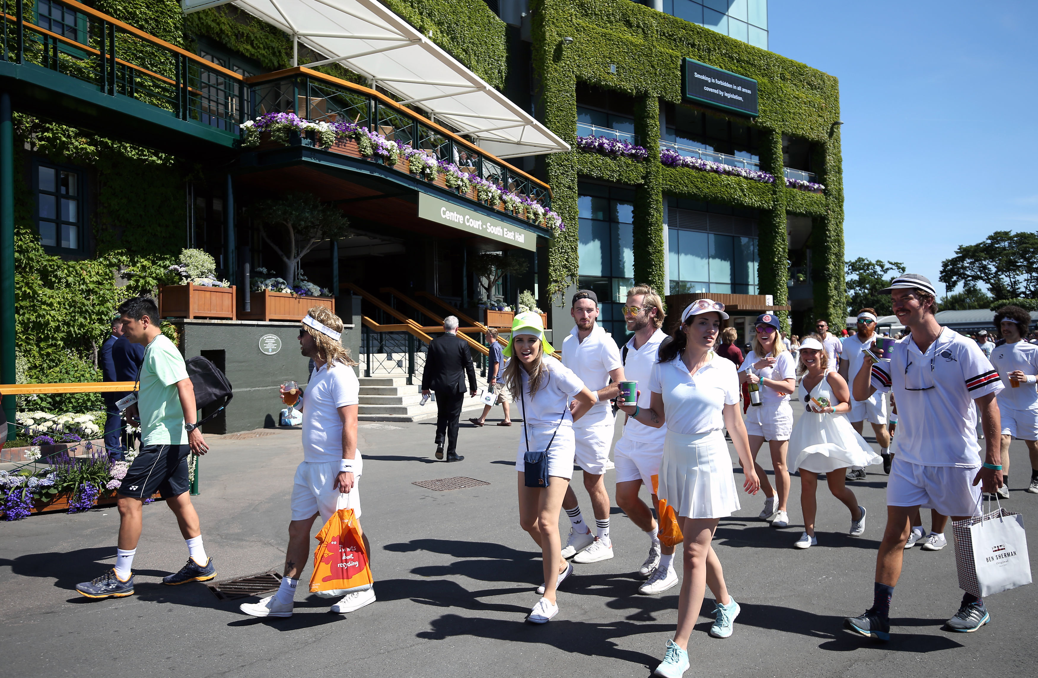 Spectators are led into the grounds on day one of the Wimbledon Championships at the All England Lawn Tennis and Croquet Club