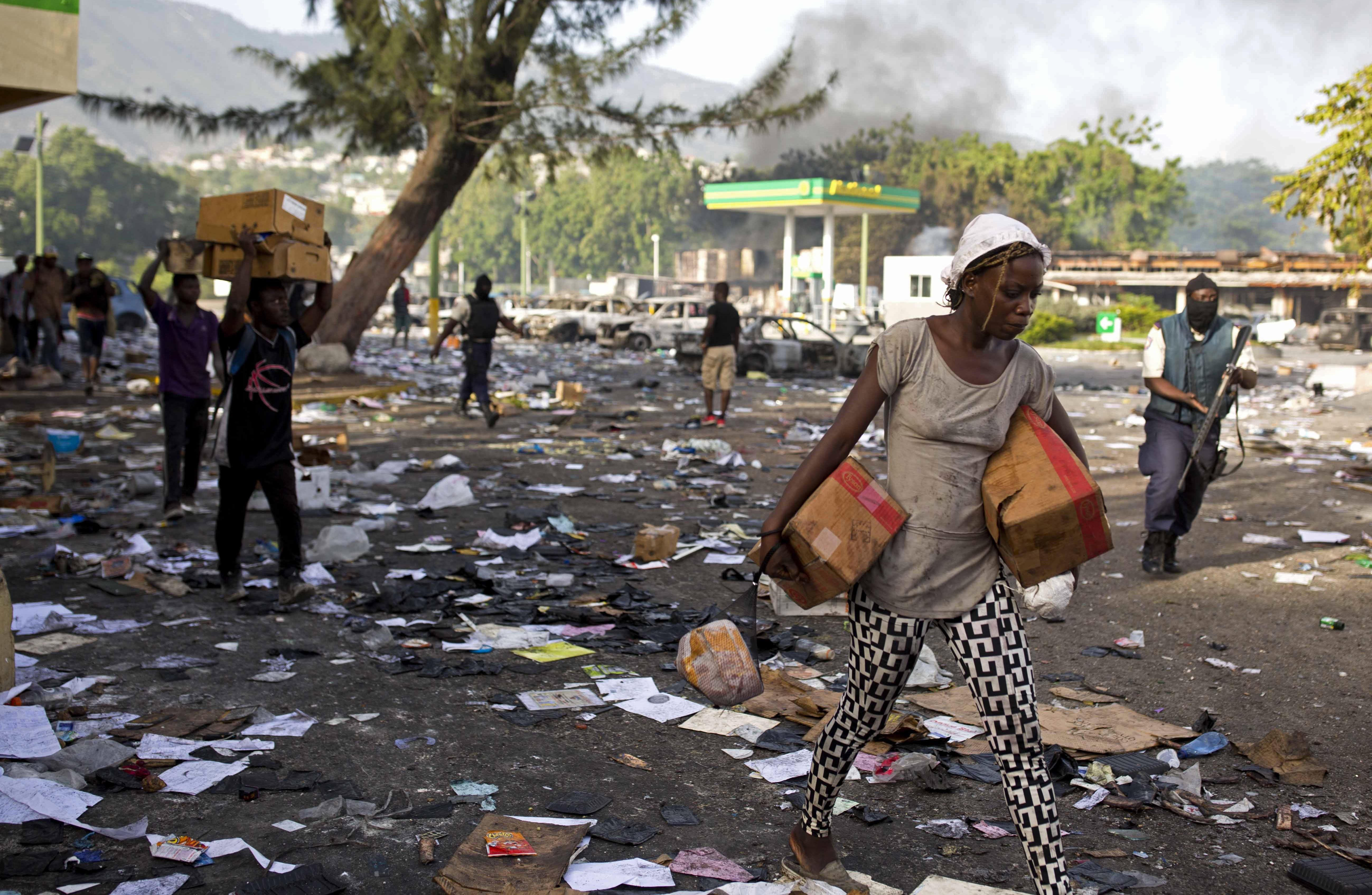 People carry merchandise from the Delimart supermarket complex in Port-au-Prince