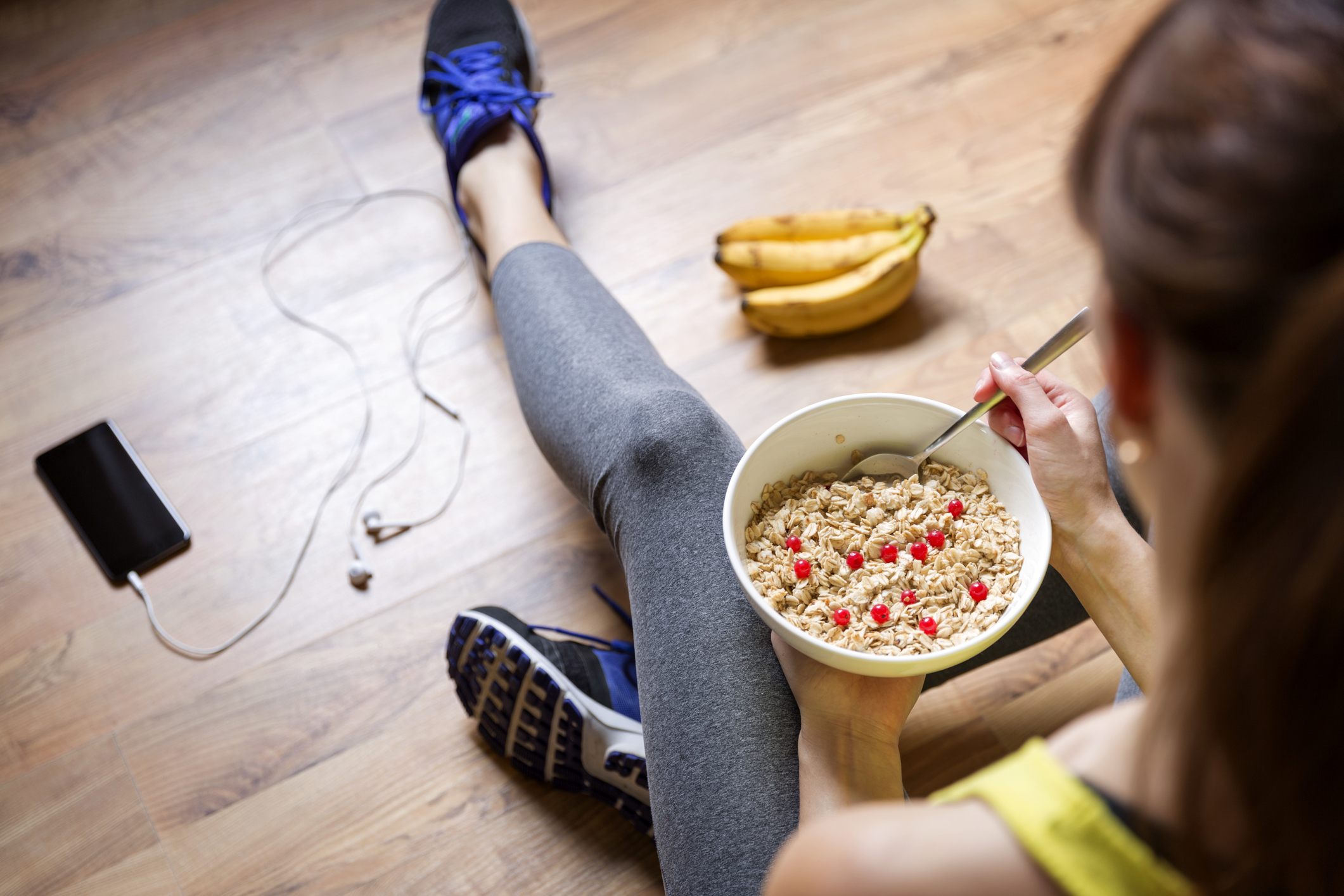 Young girl eating a oatmeal with berries after a workout. Fitness and healthy lifestyle concept.
