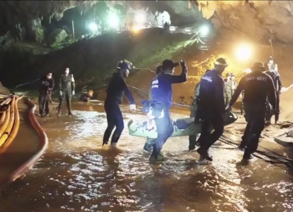 Rescuers hold an evacuated boy inside the Tham Luang Nang Non cave in Thailand 