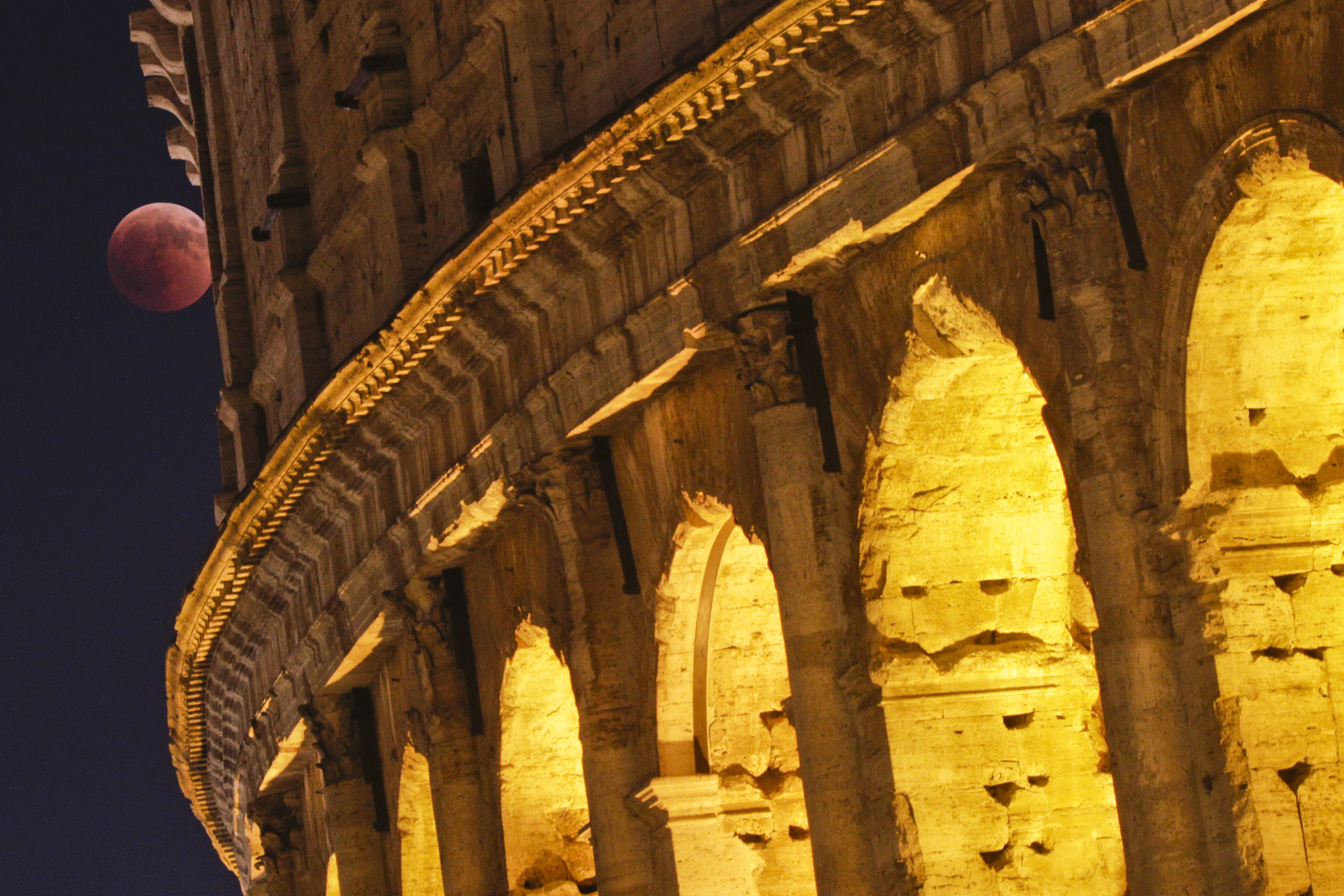 The moon is framed by the Colosseum during a complete lunar eclipse, in Rome