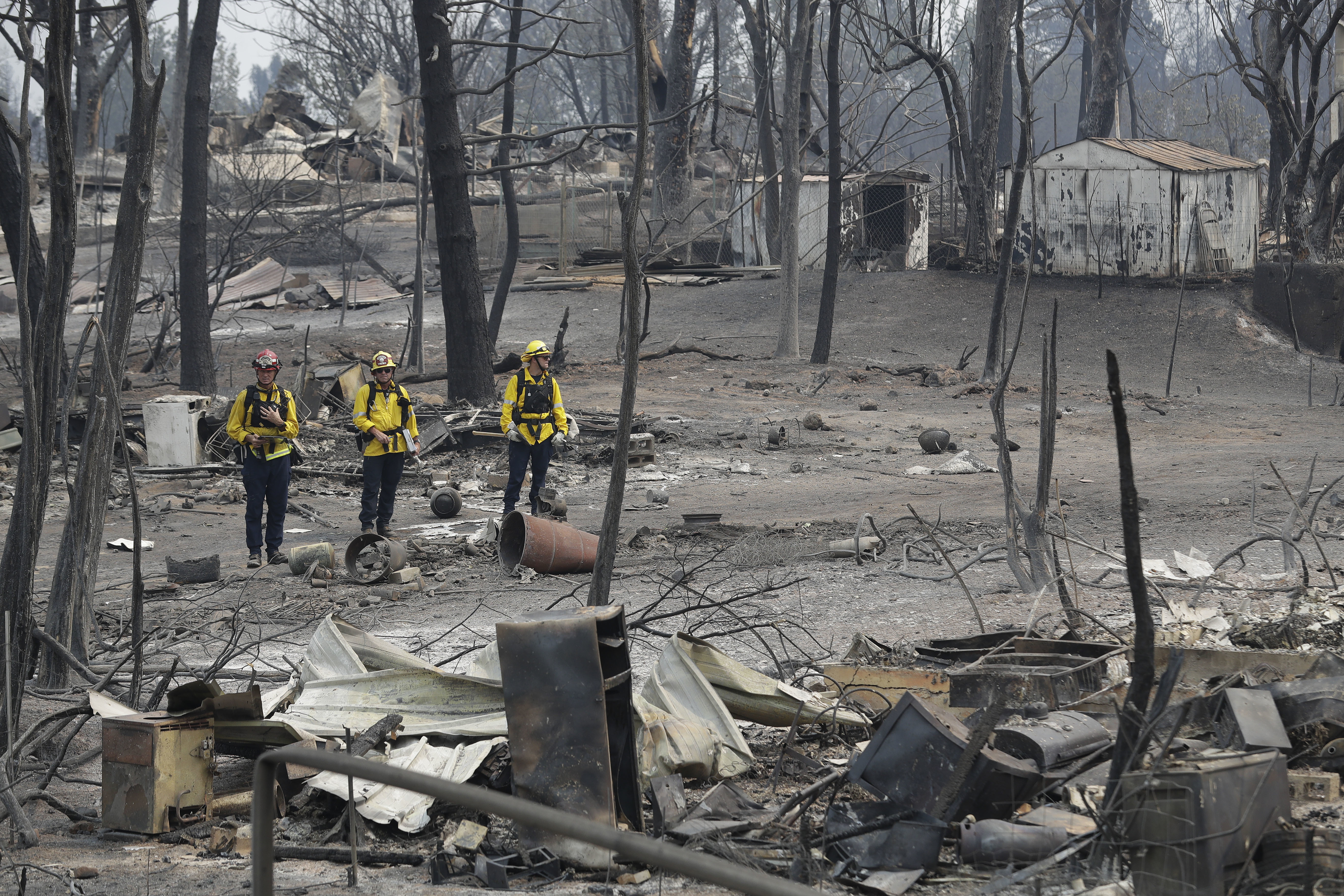 Firefighters assess the damage in the aftermath of a wildfire in Keswick, California 