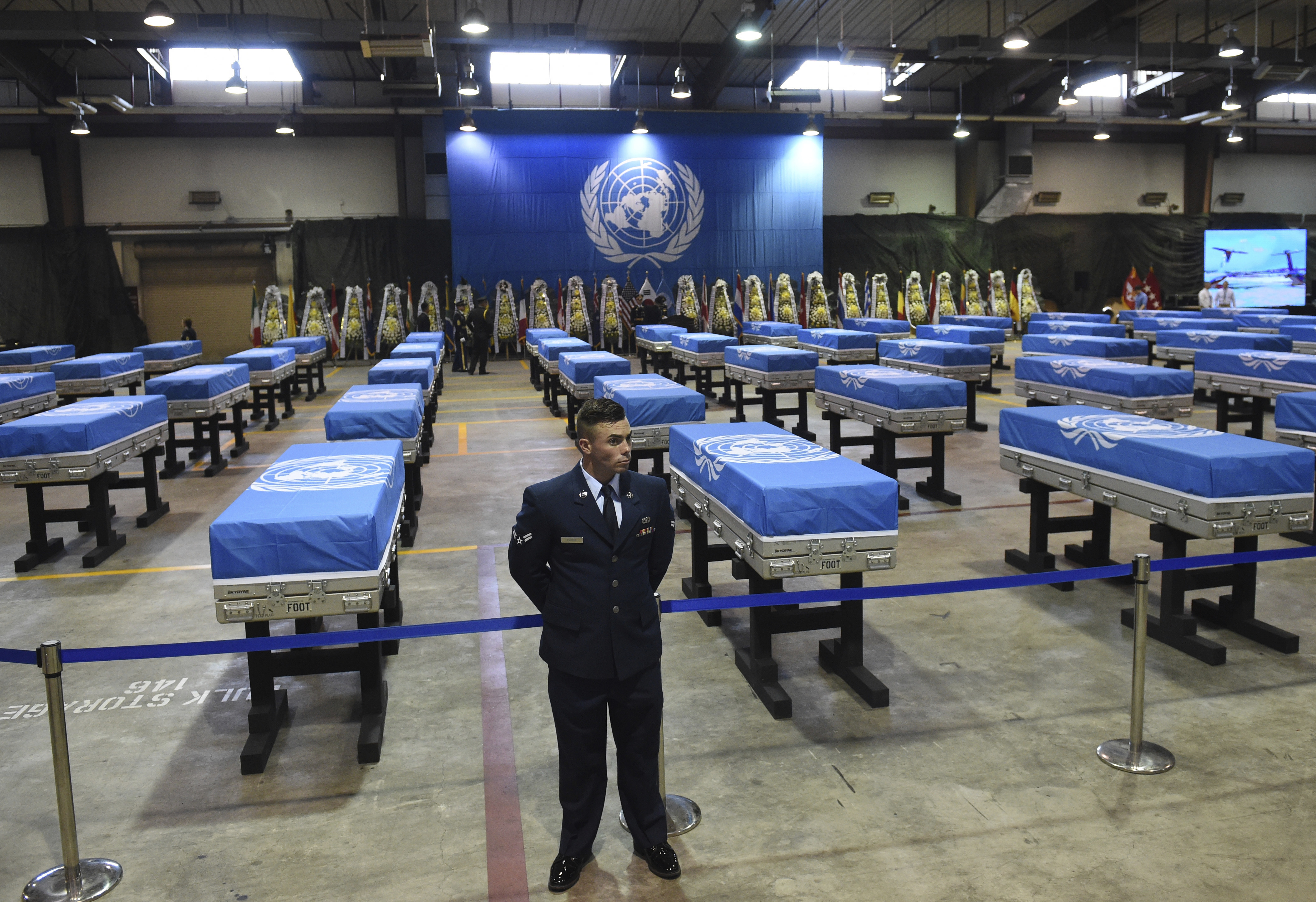 A US airman stands guard next to coffins containing remains of US soldiers killed in the Korean War and collected in North Korea before a repatriation ceremony at Osan Air Base in Pyeongtaek