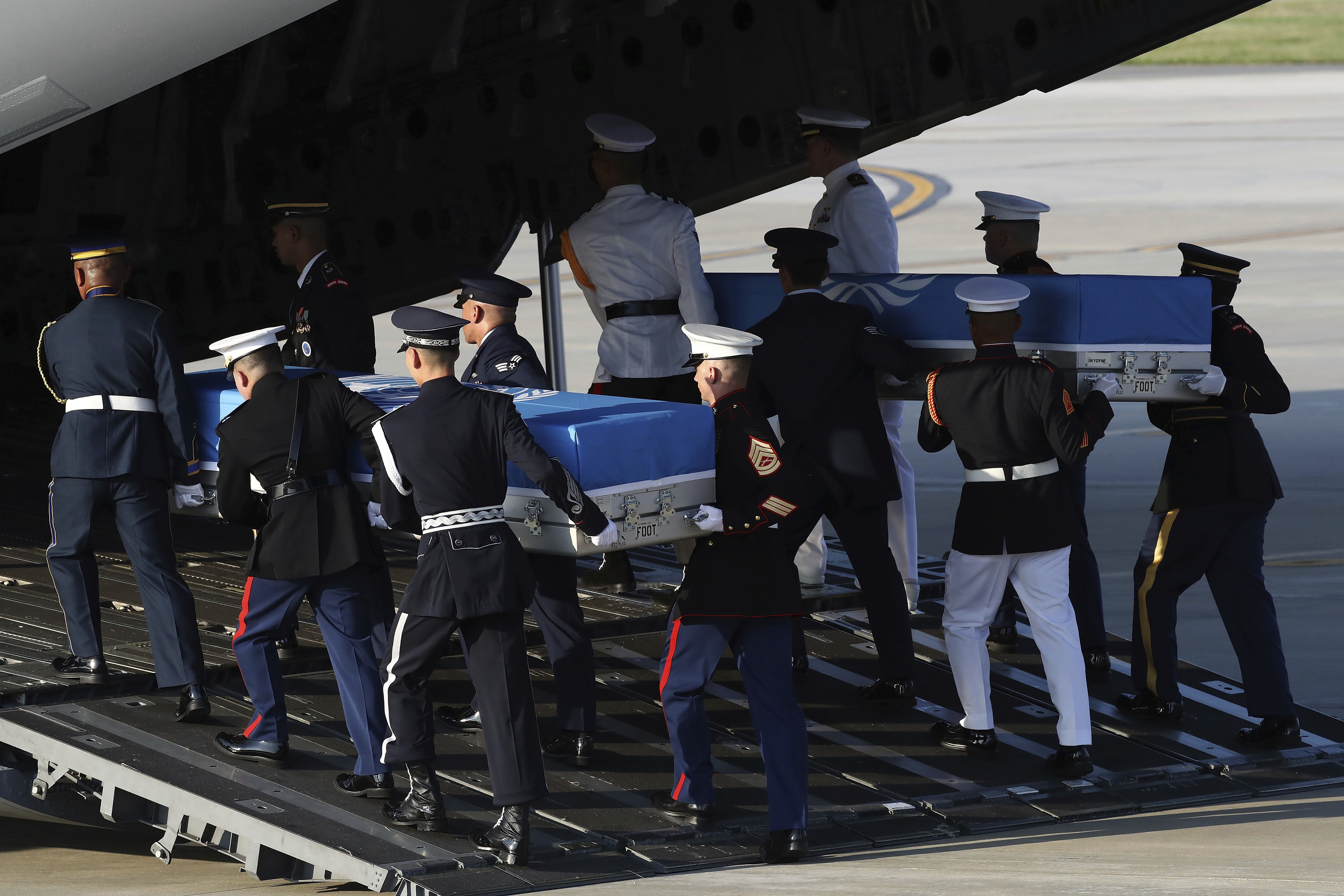 UN honour guards carry the remains of US servicemen killed in the Korean War 