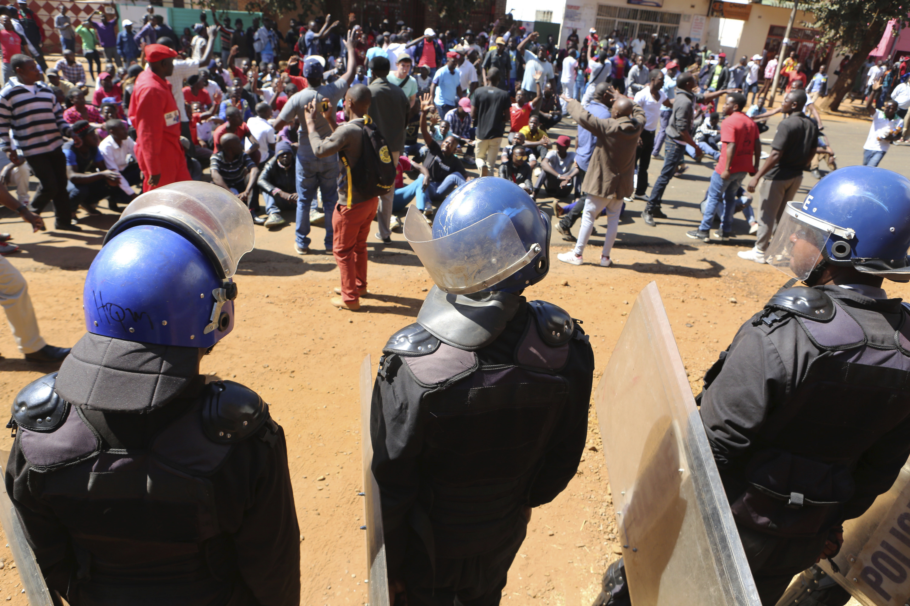Police block dozens of opposition party supporters from entering the Zimbabwe Electoral Commission offices in Harare