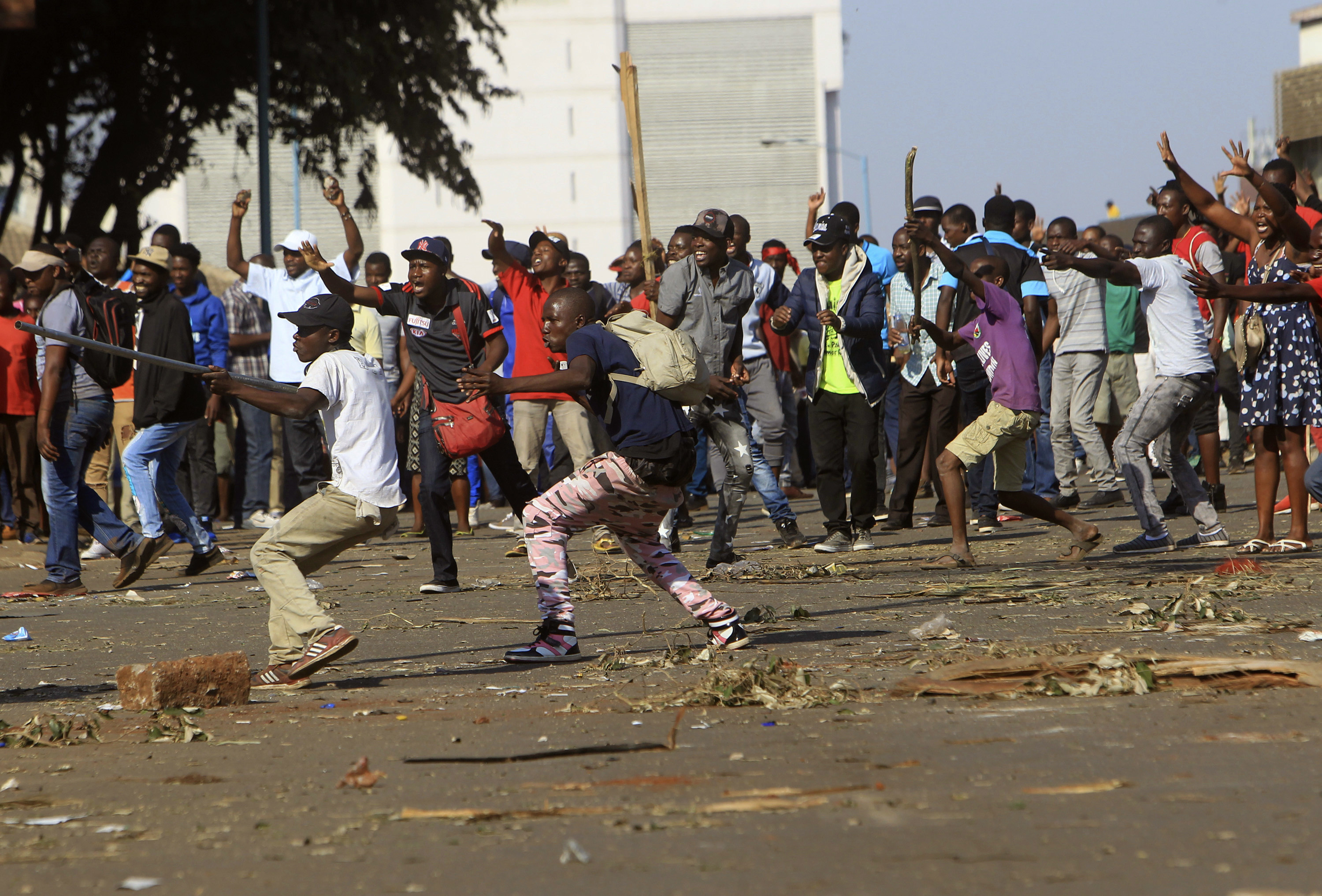 Opposition party supporters react after police fire tear gas in Harare
