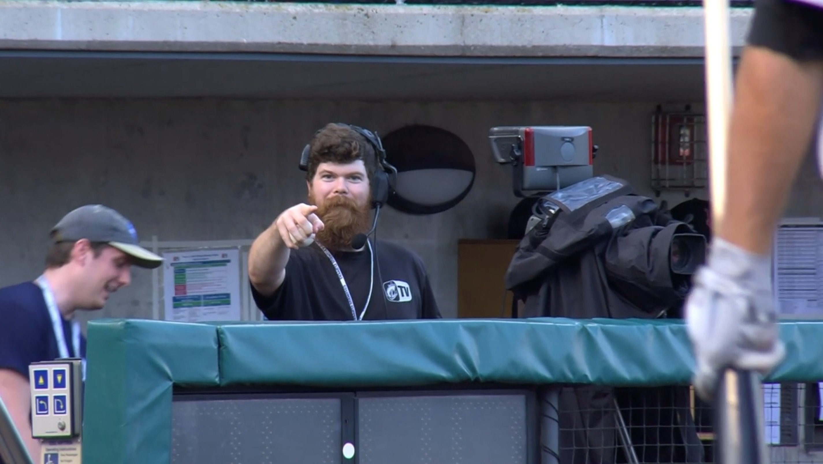 A cameraman points down the camera after taking a catch