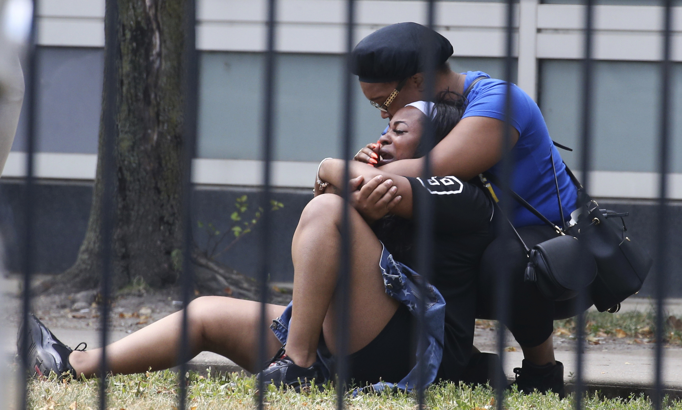 Two women cry outside the Stroger Hospital in Chicago, after they were asked to leave due to overwhelming crowds of family and friends of shooting victims