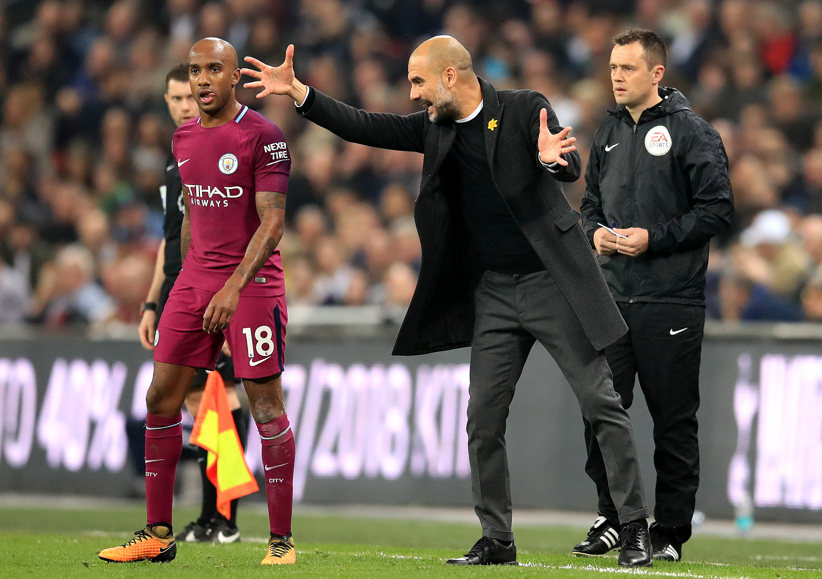 Manchester City manager Pep Guardiola gives instructions to Fabian Delph