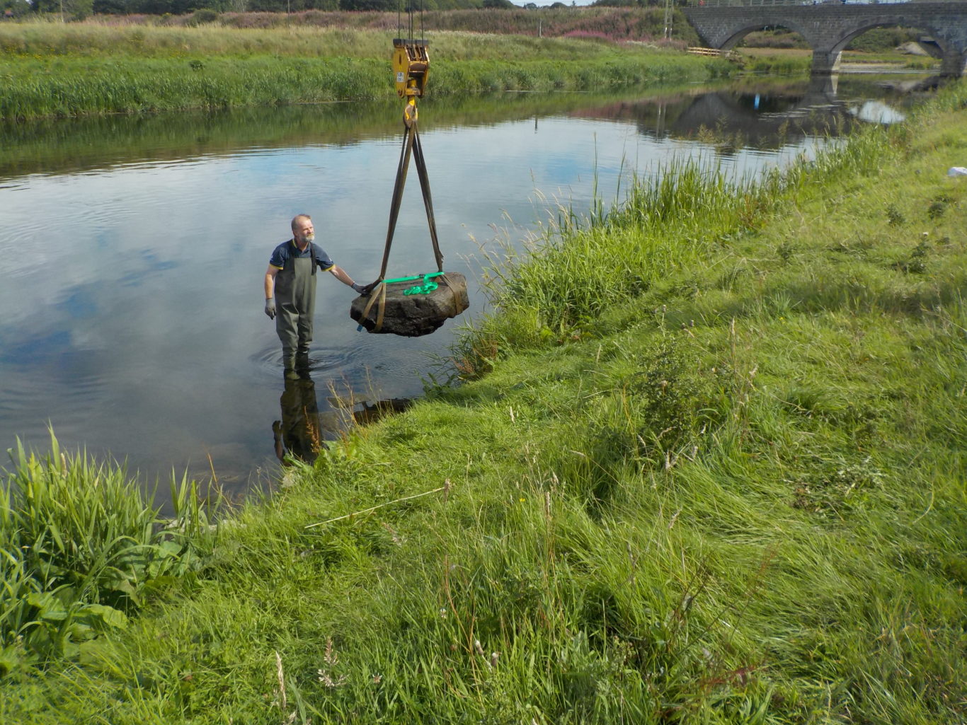 Specialists removing the stone from the river