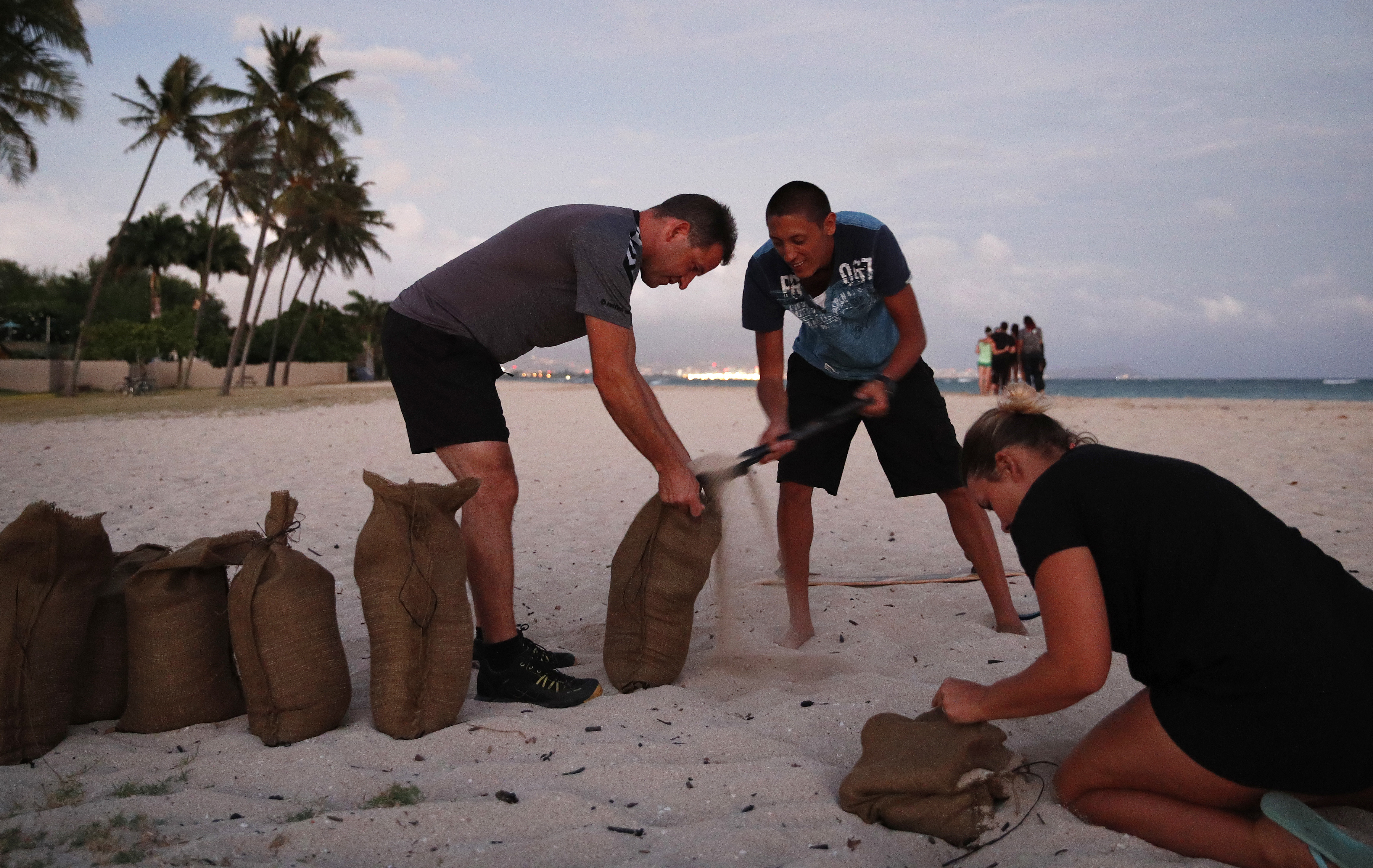 People fill up sandbags that will be used to help protect their homes
