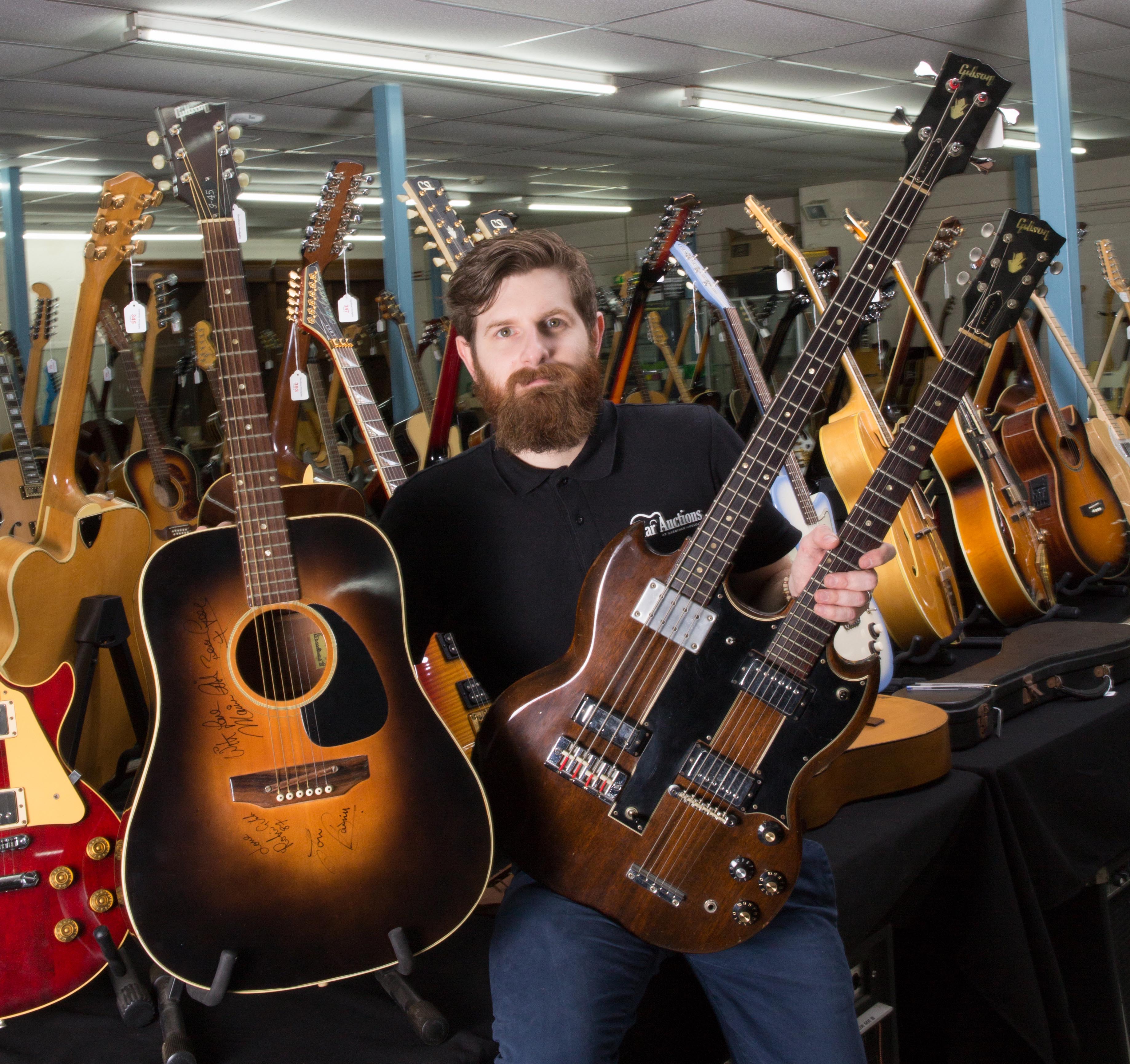 Luke Hobbs, of Wiltshire-based auctioneers Gardiner Houlgate, with the Maurice Gibb-owned Gibson J45 (left) and Gibson doubleneck guitars (Clare Hobbs Photography/PA)