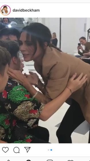 Victoria Beckham kisses her family on the front row