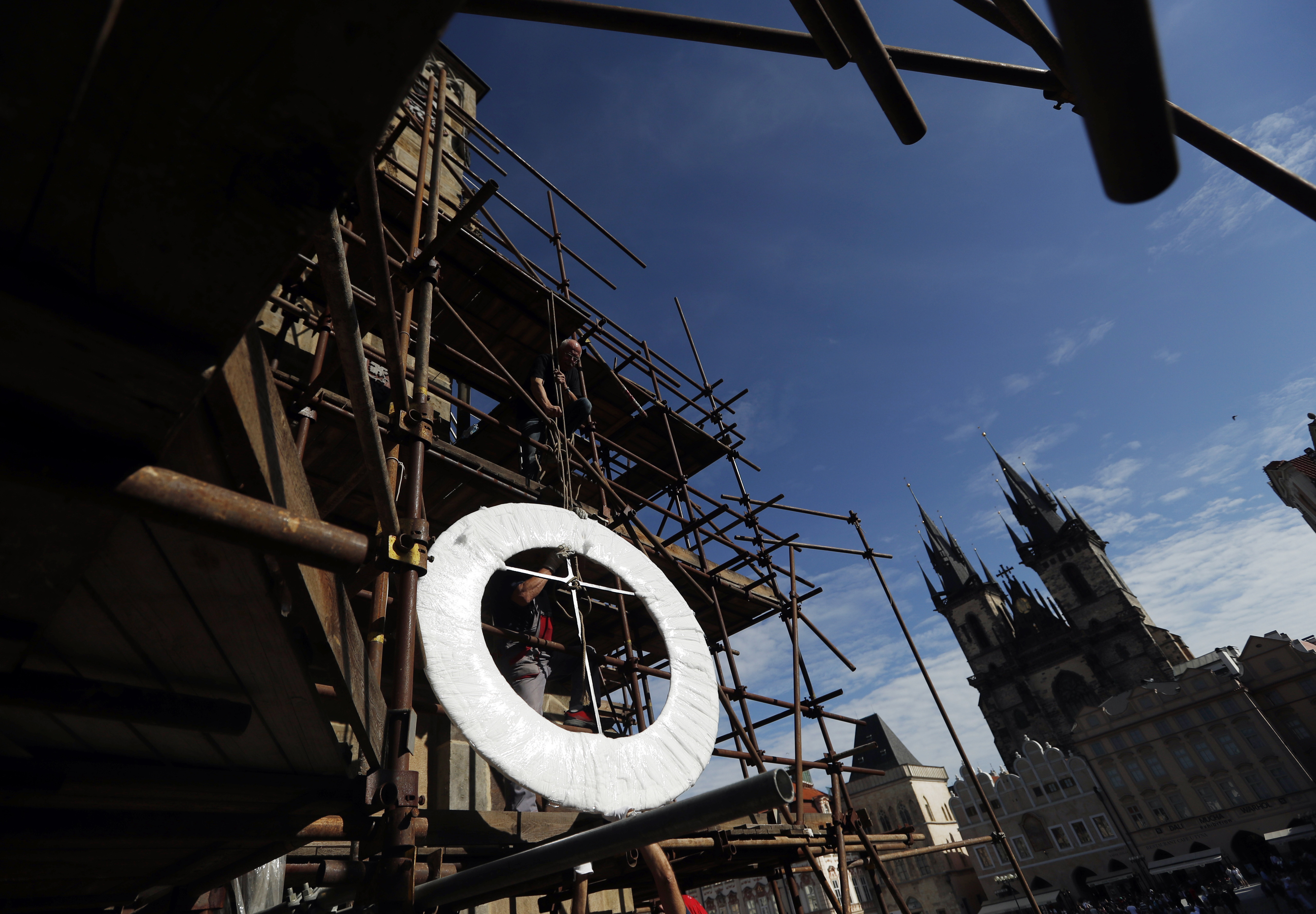 Part of the famed Prague's medieval astronomical clock is lifted up to scaffolding
