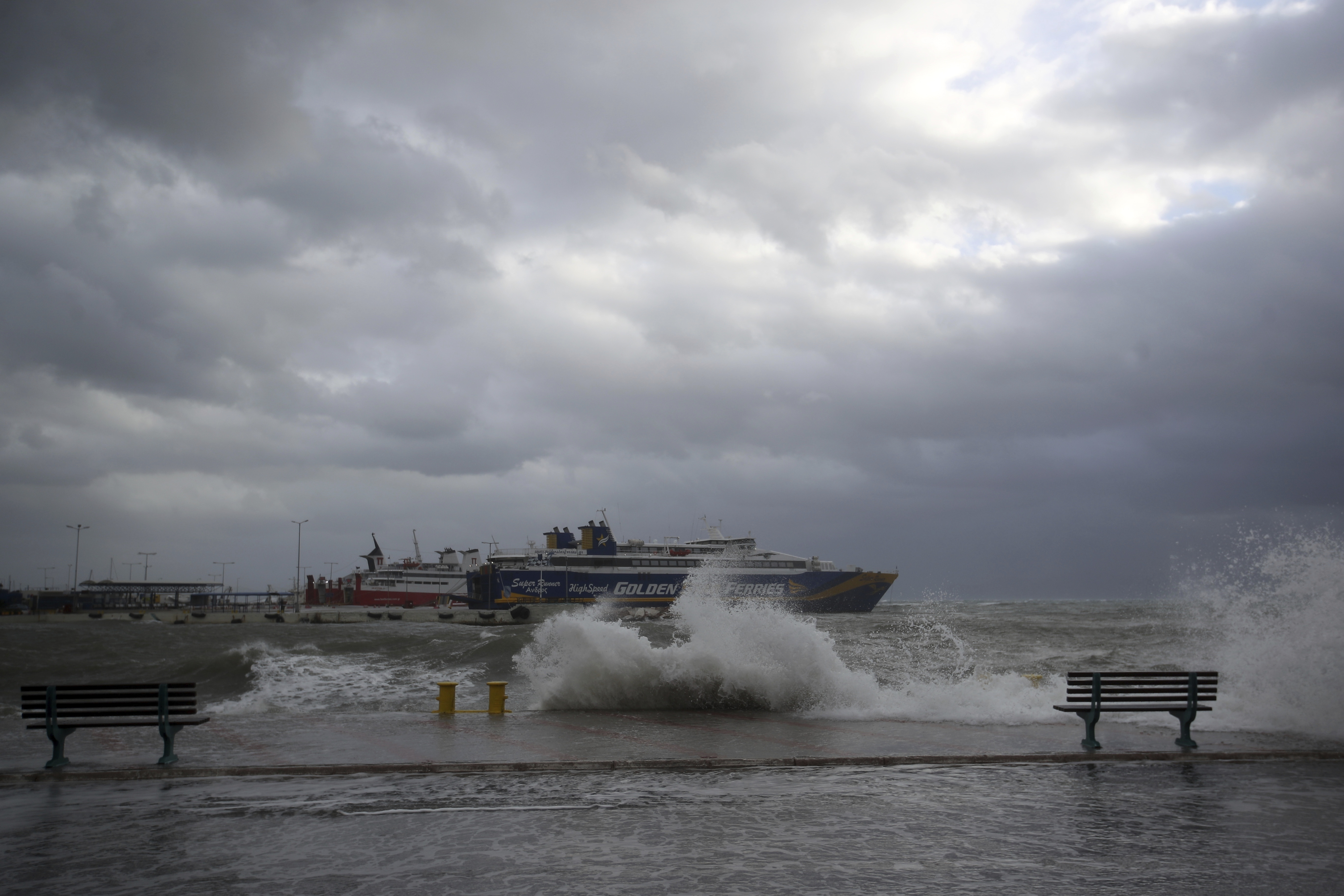 Waves cover the coastal road during bad weather at the port of Rafina, east of Athens