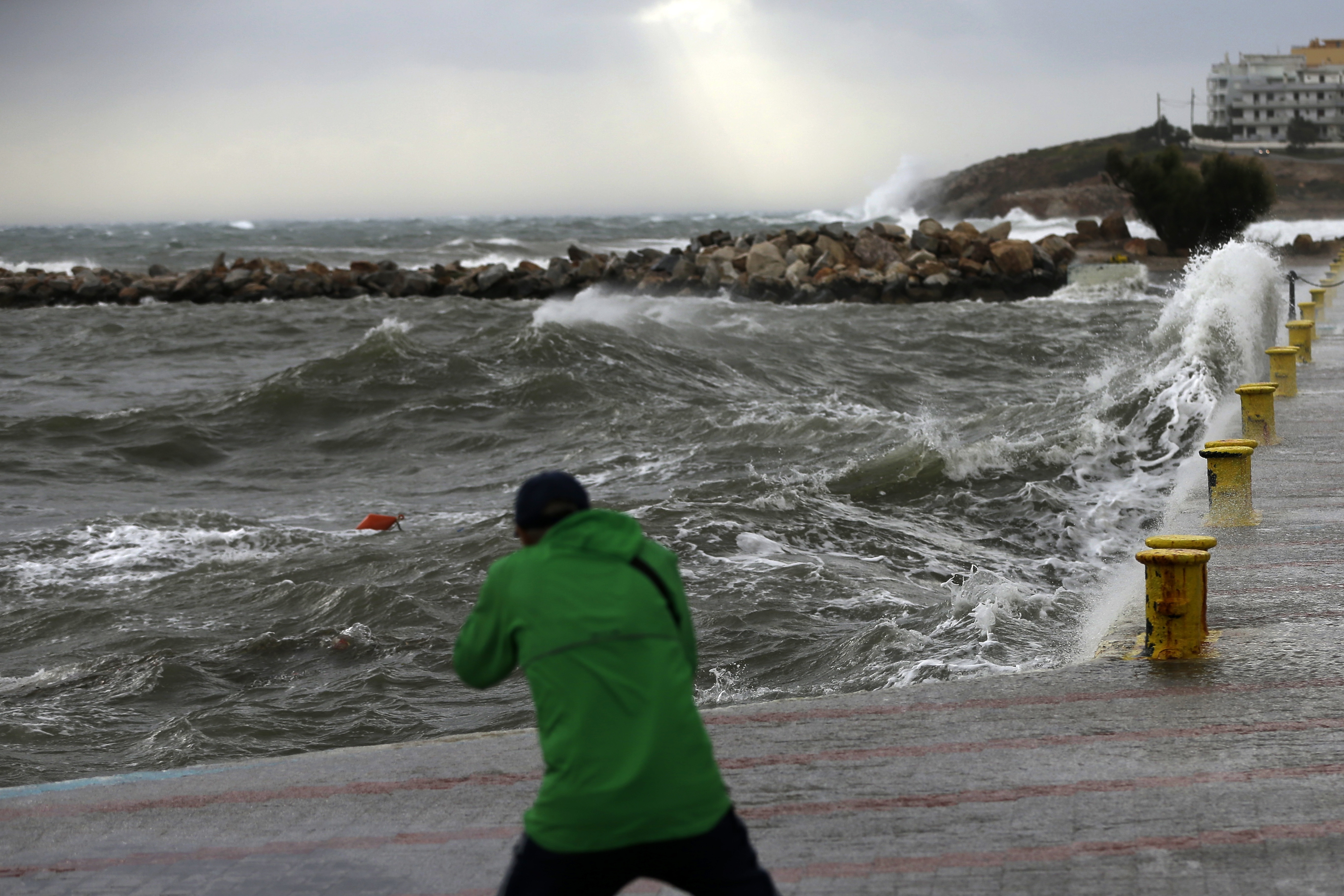 A man takes a photograph during bad weather at the port of Rafina, east of Athens 