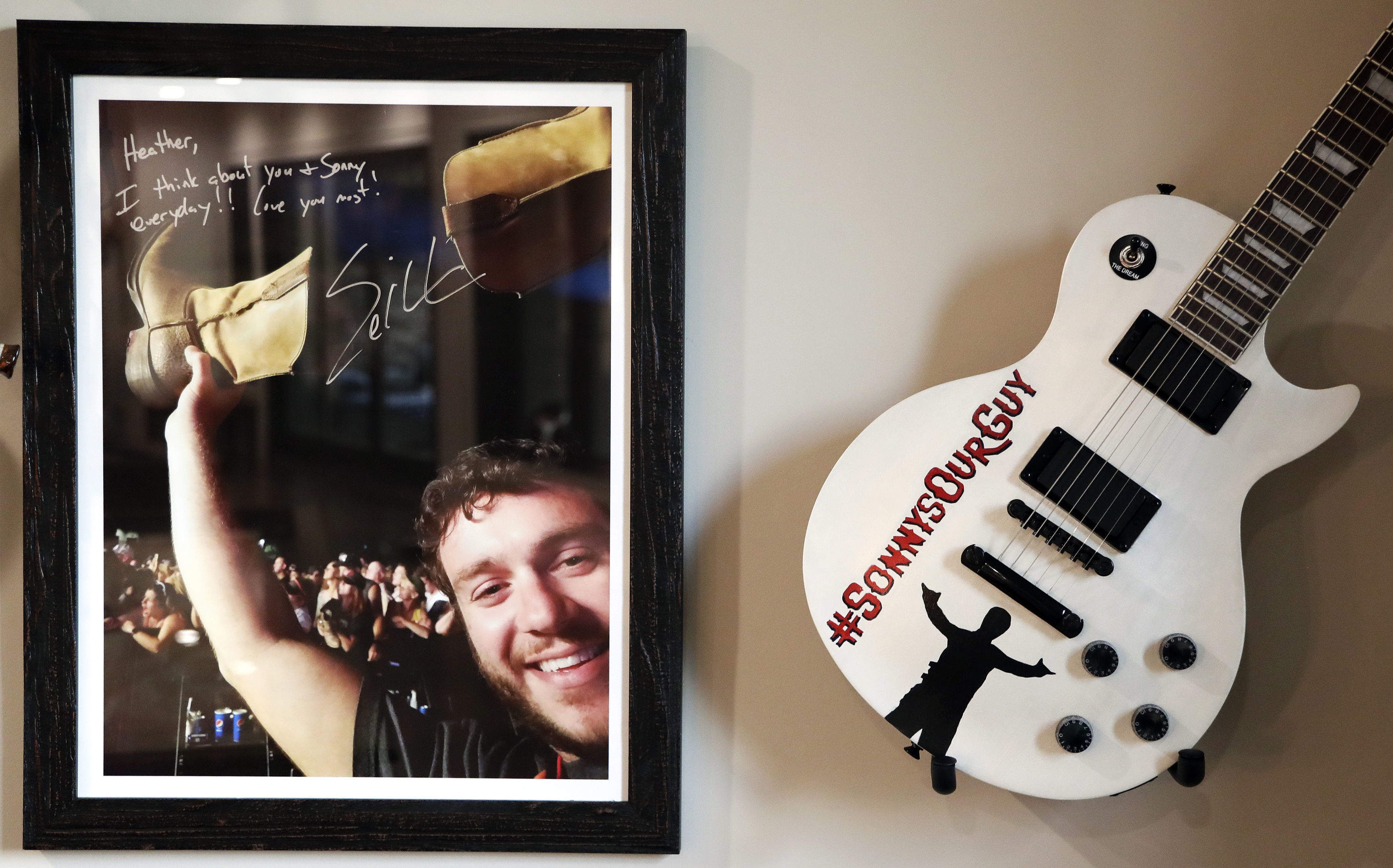 A picture of Sonny Melton, autographed by Eric Church, and a guitar from the Eric Church fan club