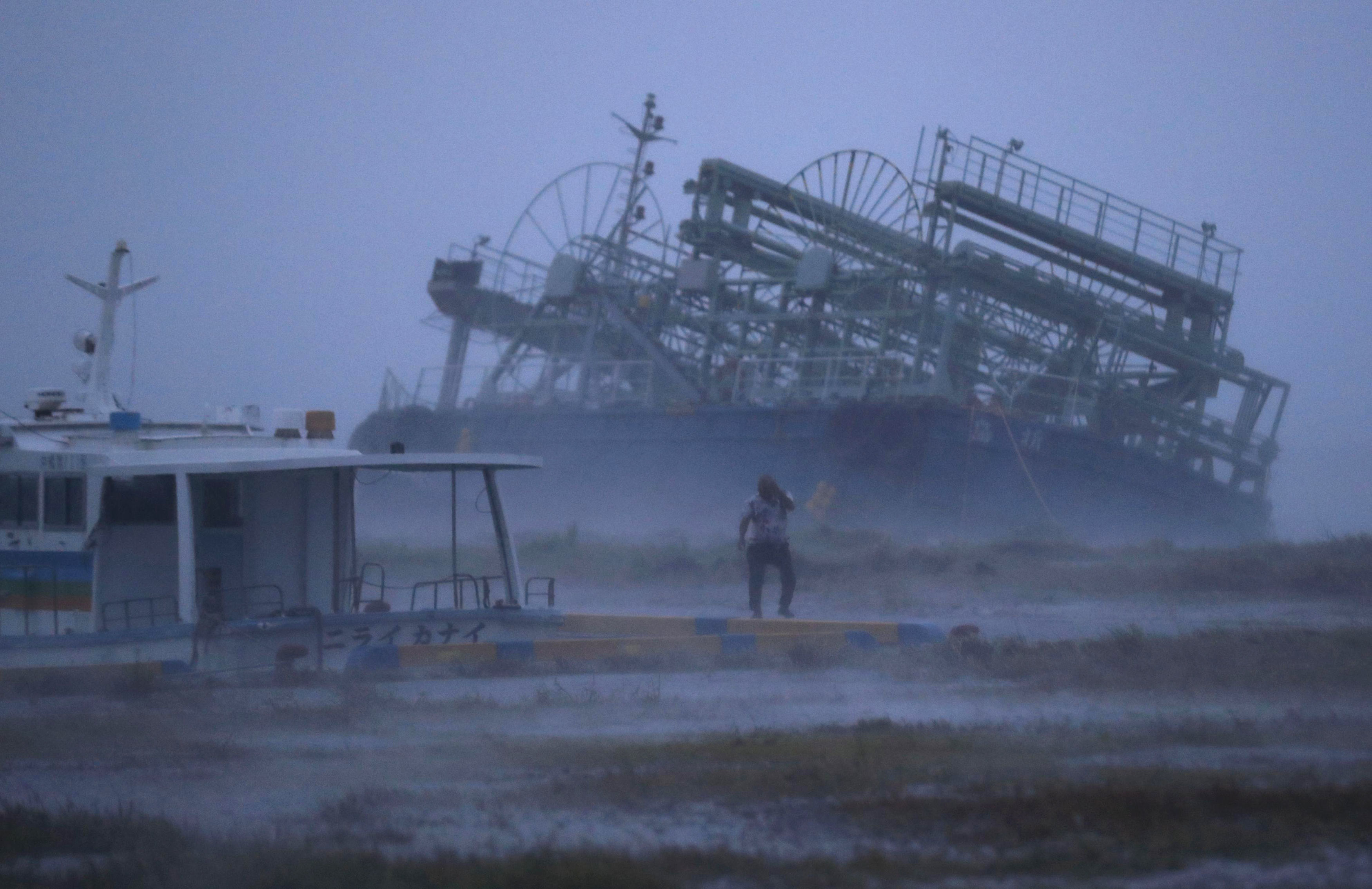 A vessel tilts as it ran ashore at a pier as a typhoon approached Yonabaru, Okinawa prefecture, in southern Japan