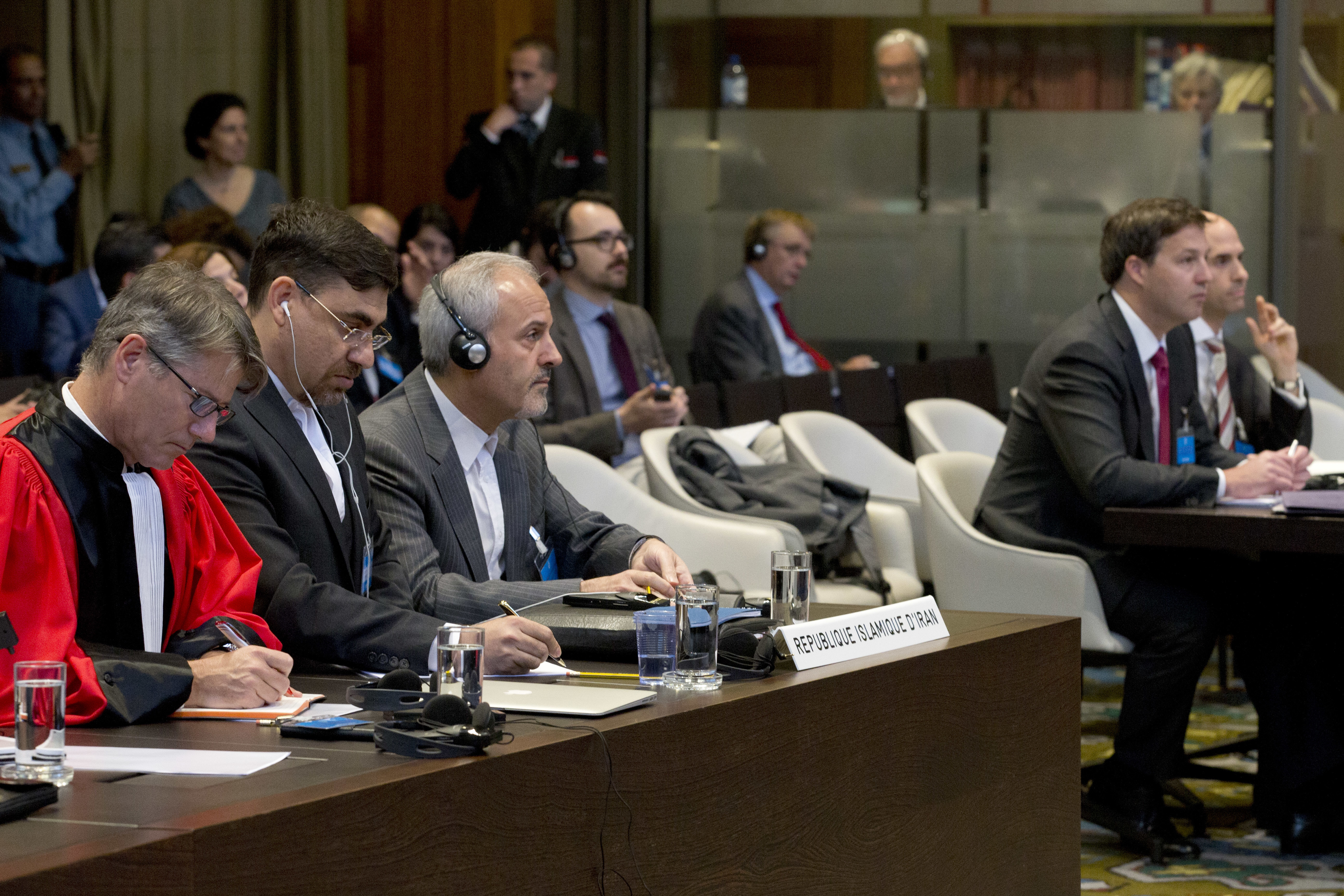 Mohammed Zahedin Labbaf, third left, of the Islamic Republic of Iran, and the US delegation, right, listen to the ruling of the judges at the International Court of Justice in The Hague, Netherlands