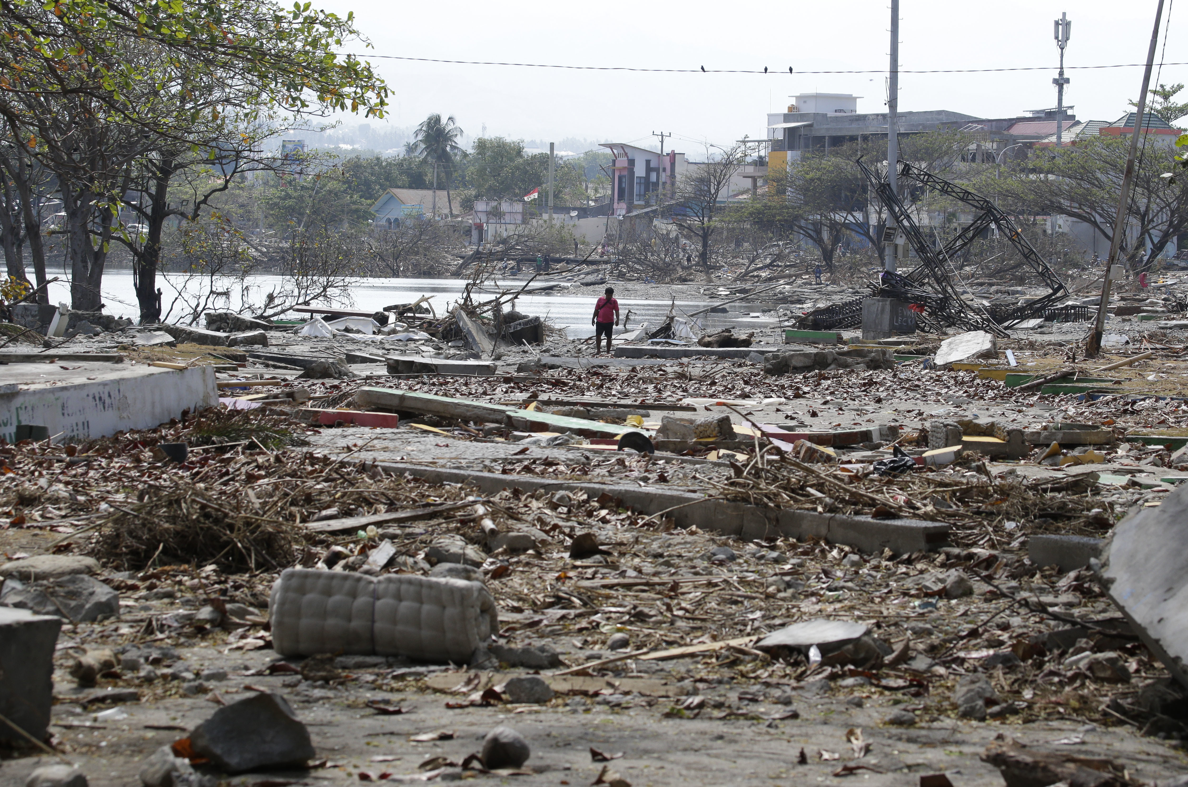 A man walks past the remains of structures at a park in Palu