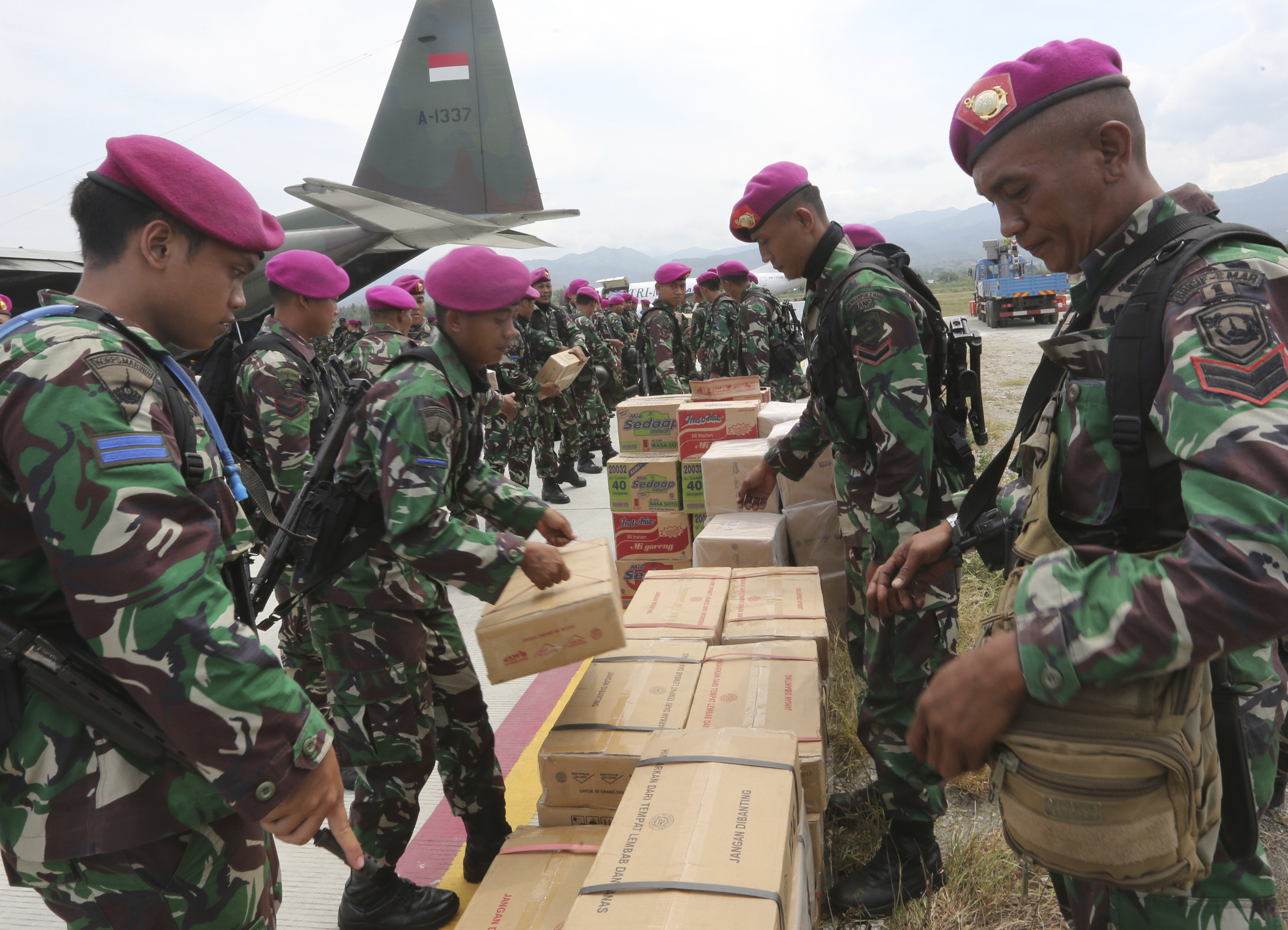 Indonesian military personnel help distribute relief aid at Mutiara Sis Al-Jufri airport