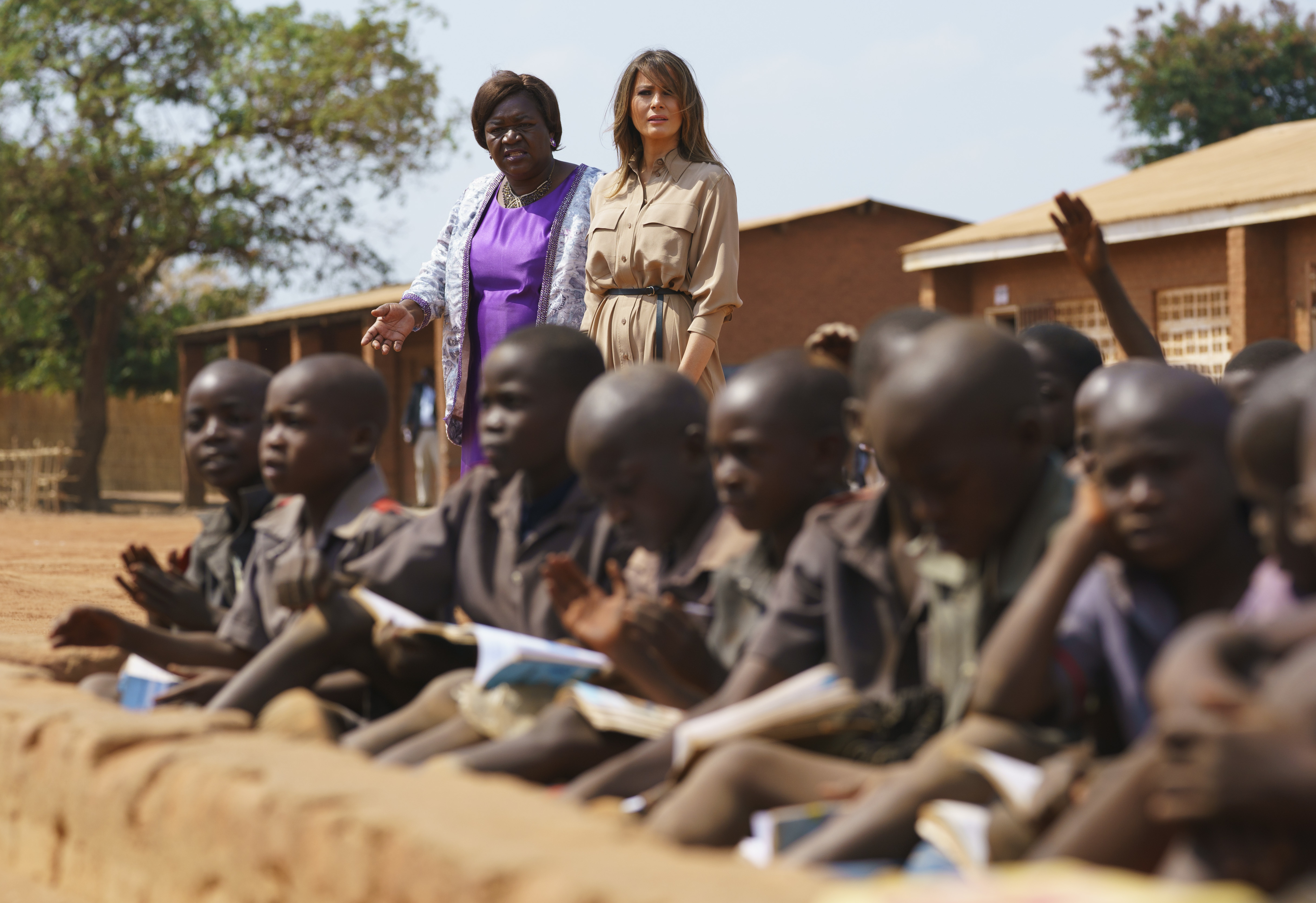 Melania Trump walks with head teacher Maureen Masi to observe an outdoor class as she visits Chipala Primary School in Lilongwe, Malawi
