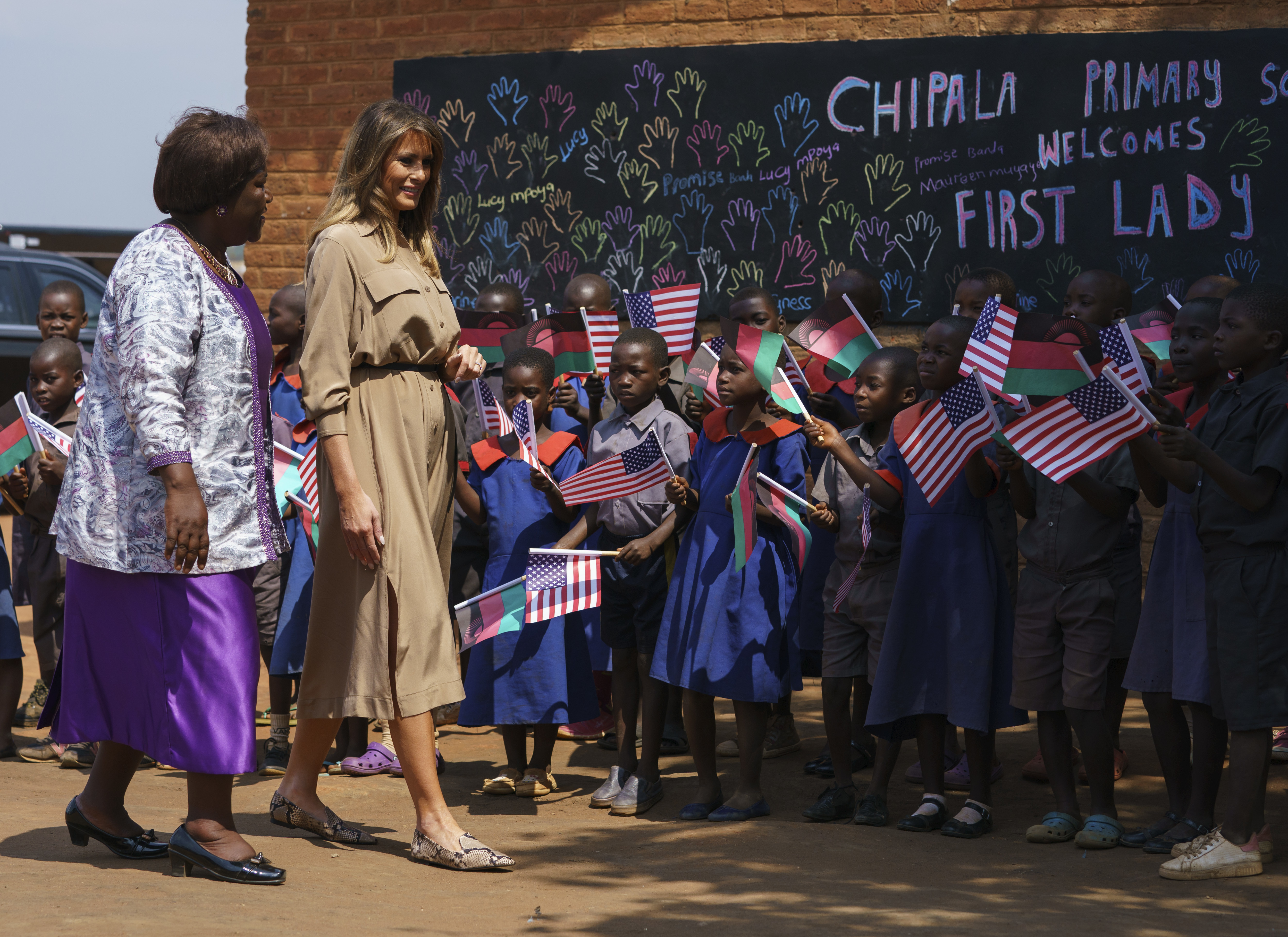First lady Melania Trump is escorted by head teacher Maureen Masi as she visits Chipala Primary School in Lilongwe, Malawi