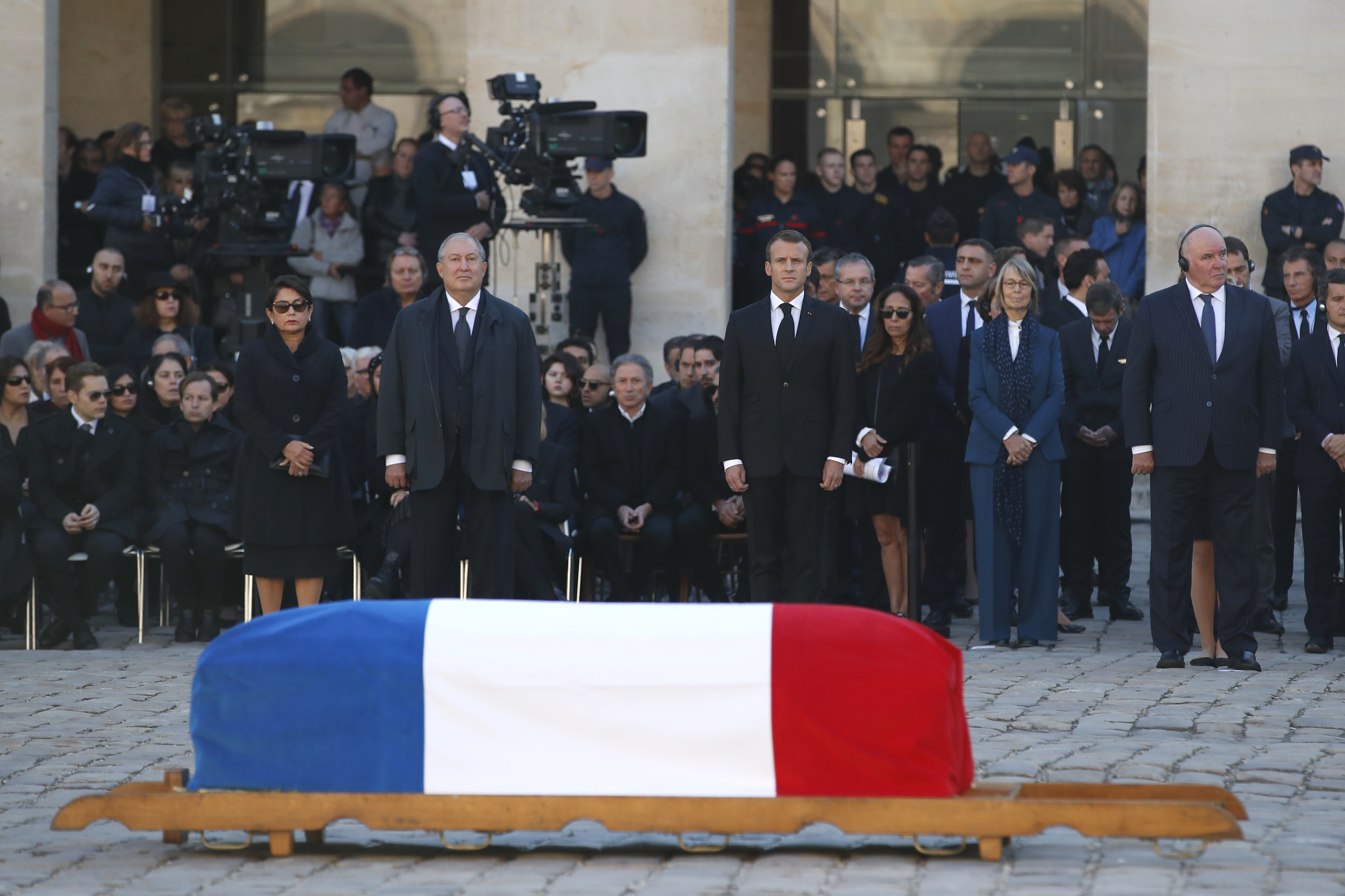 French President Emmanuel Macron stands behind the coffin of Charles Aznavour