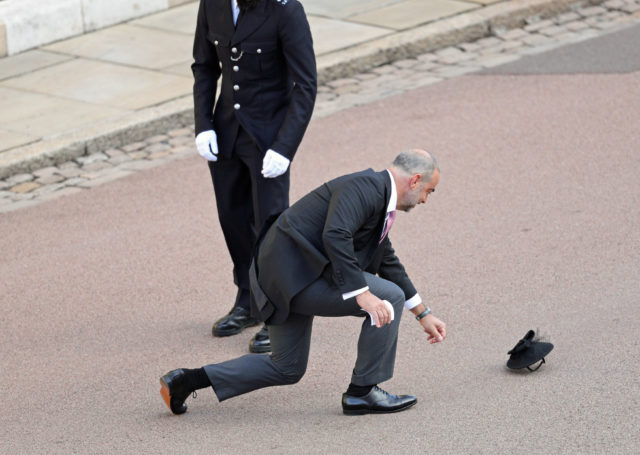 A guest retrieves a hat as he arrives for the wedding (Aaron Chown/PA)