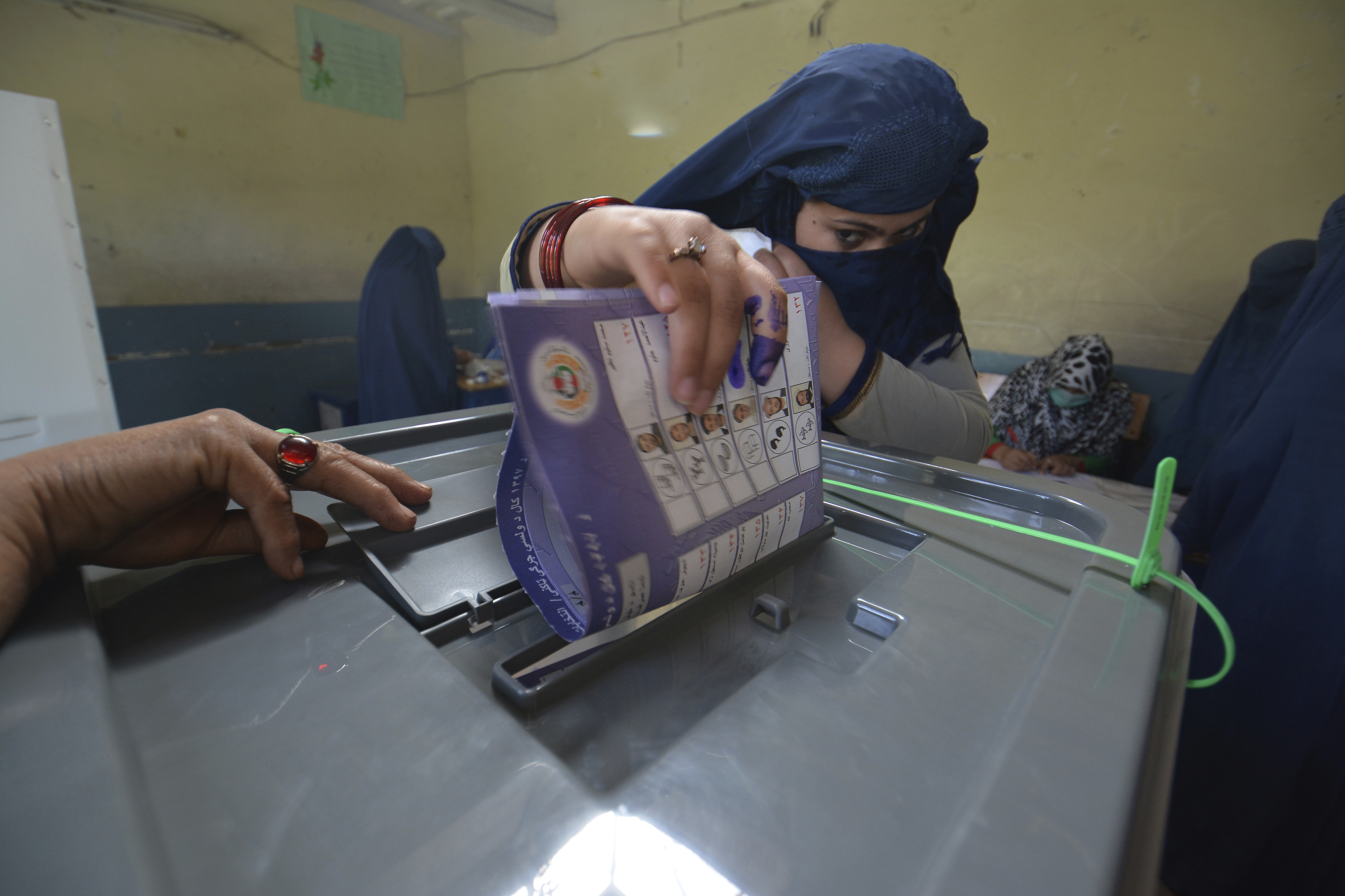 A woman casts her vote at a polling station in Jalalabad, capital of eastern Nangarhar province, Afghanistan
