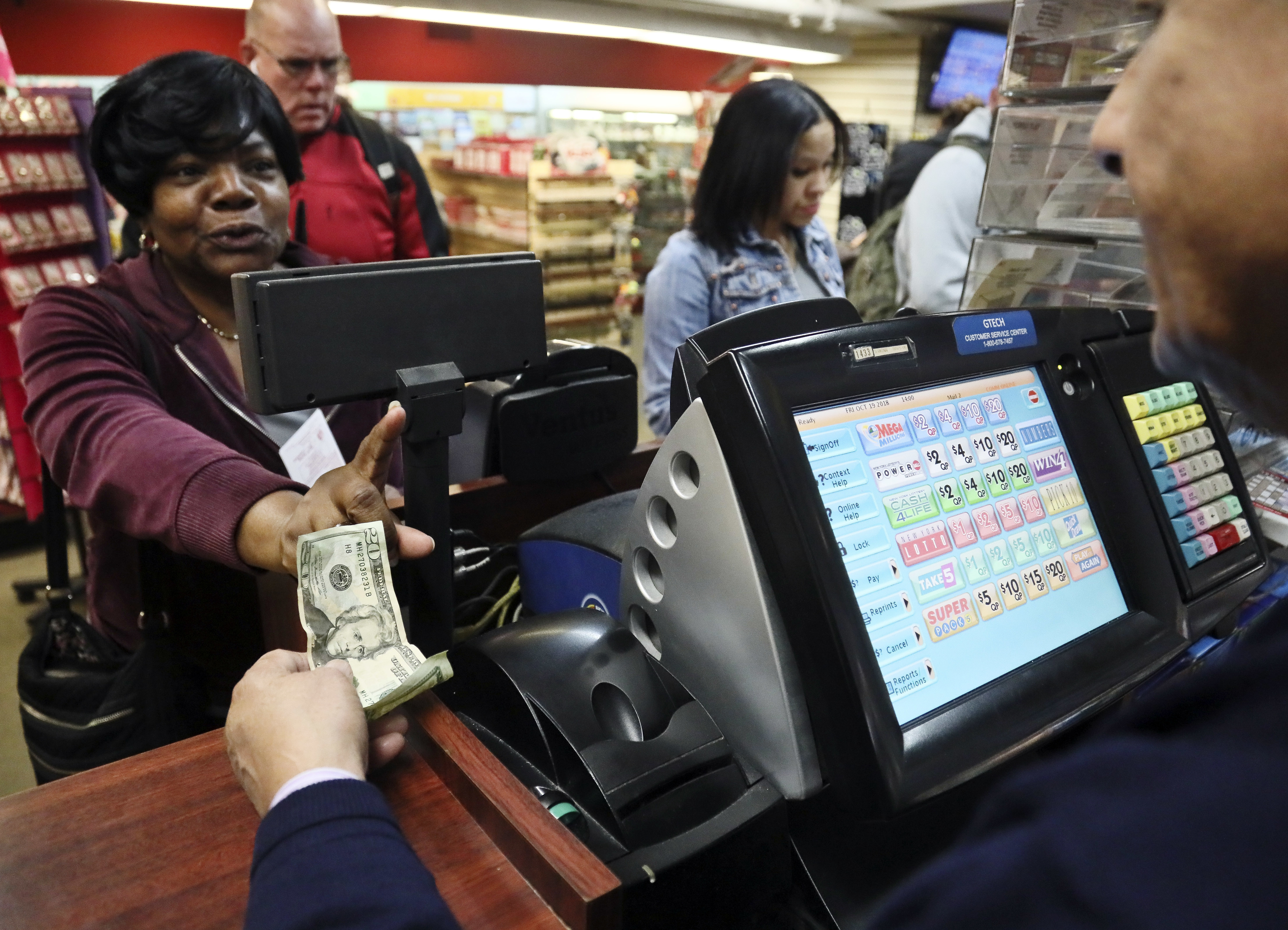 Annette Gray, left, buys lottery tickets in New York 