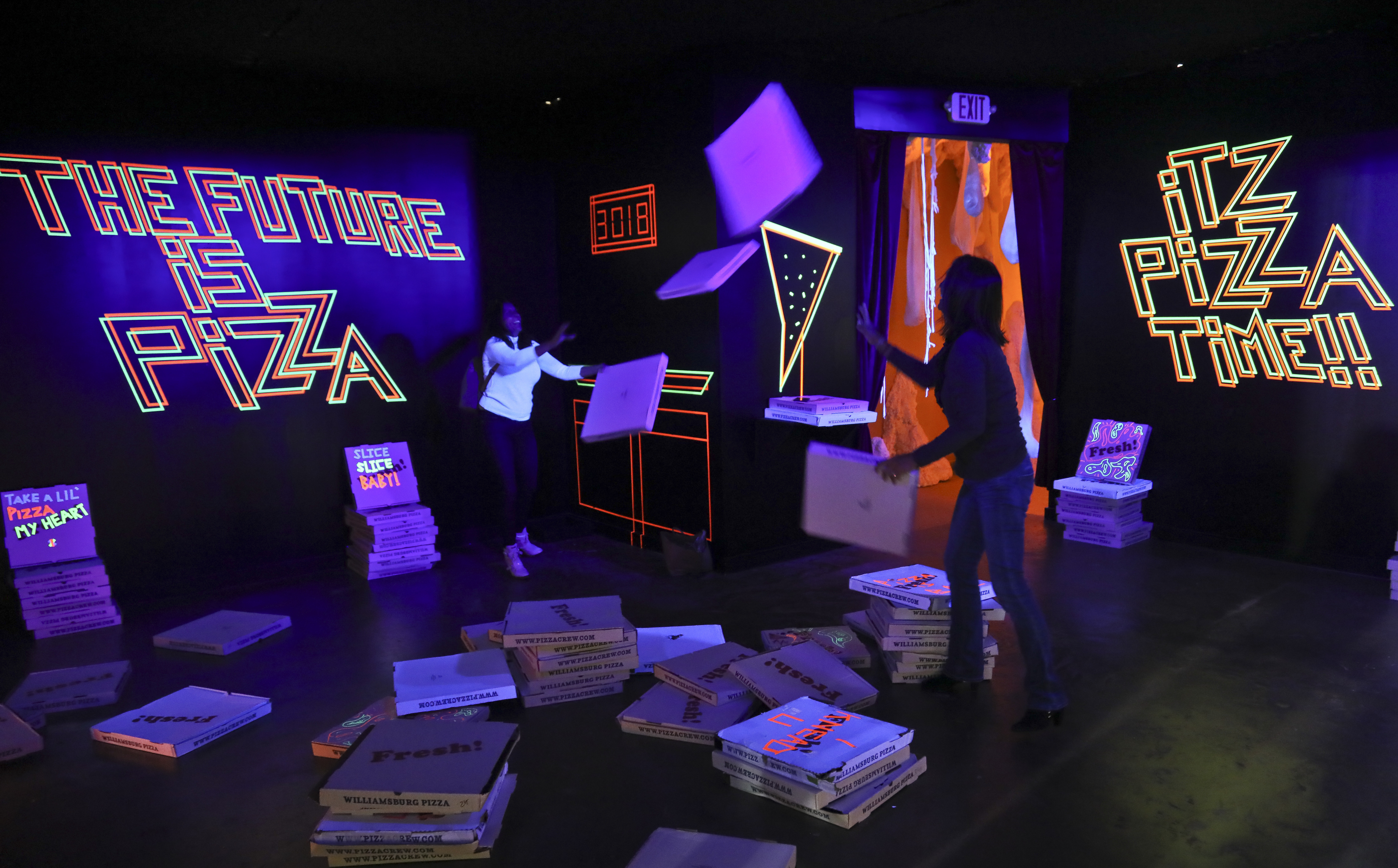 A pizza box playroom created with neon lights and colourful fluorescent tape called Gazoo, part of a group art exhibition celebrating pizza at The Museum of Pizza in New York