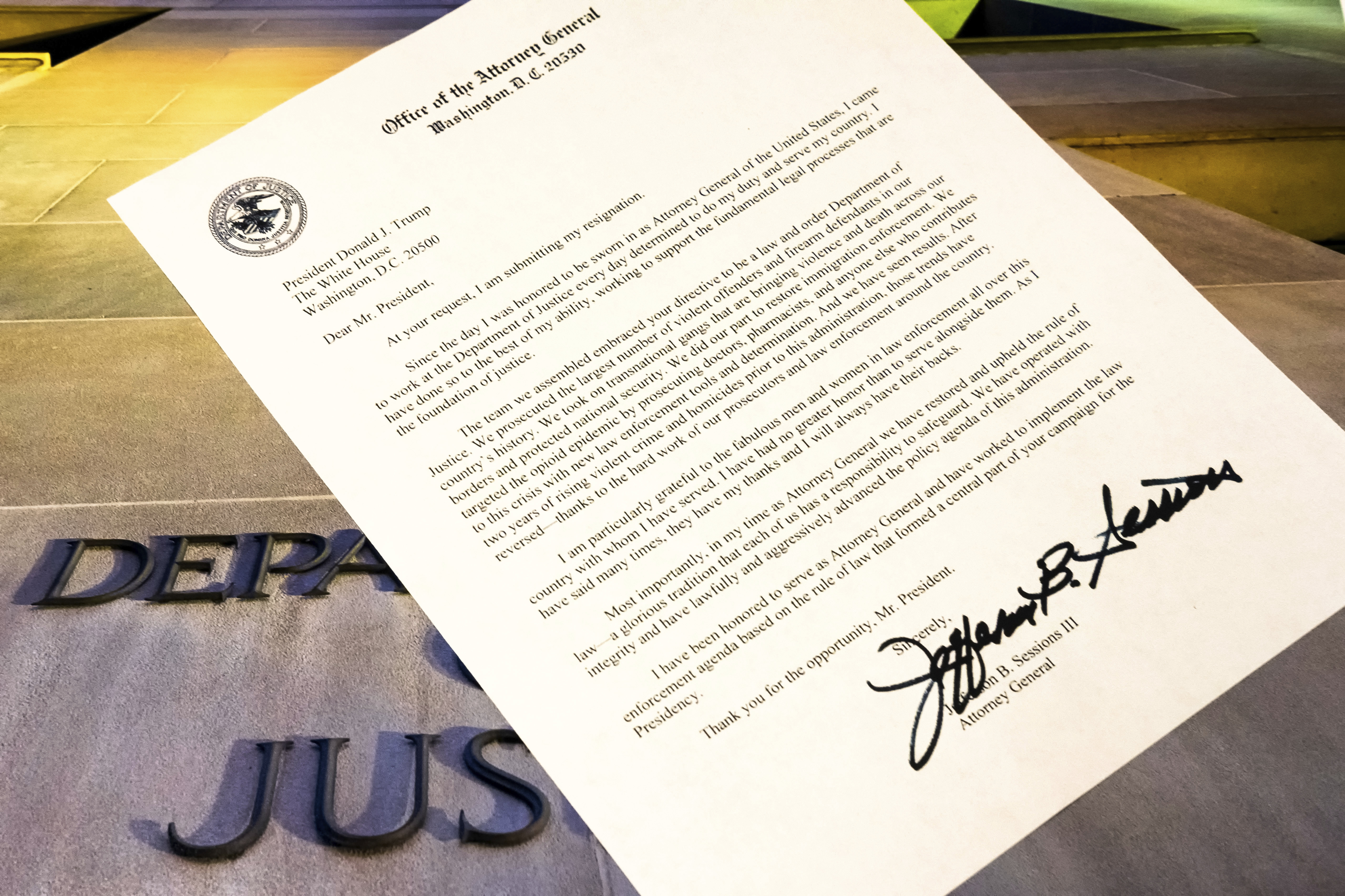 A copy of Jeff Sessions's resignation letter is photographed in Washington on an image of the exterior of the Justice Department 