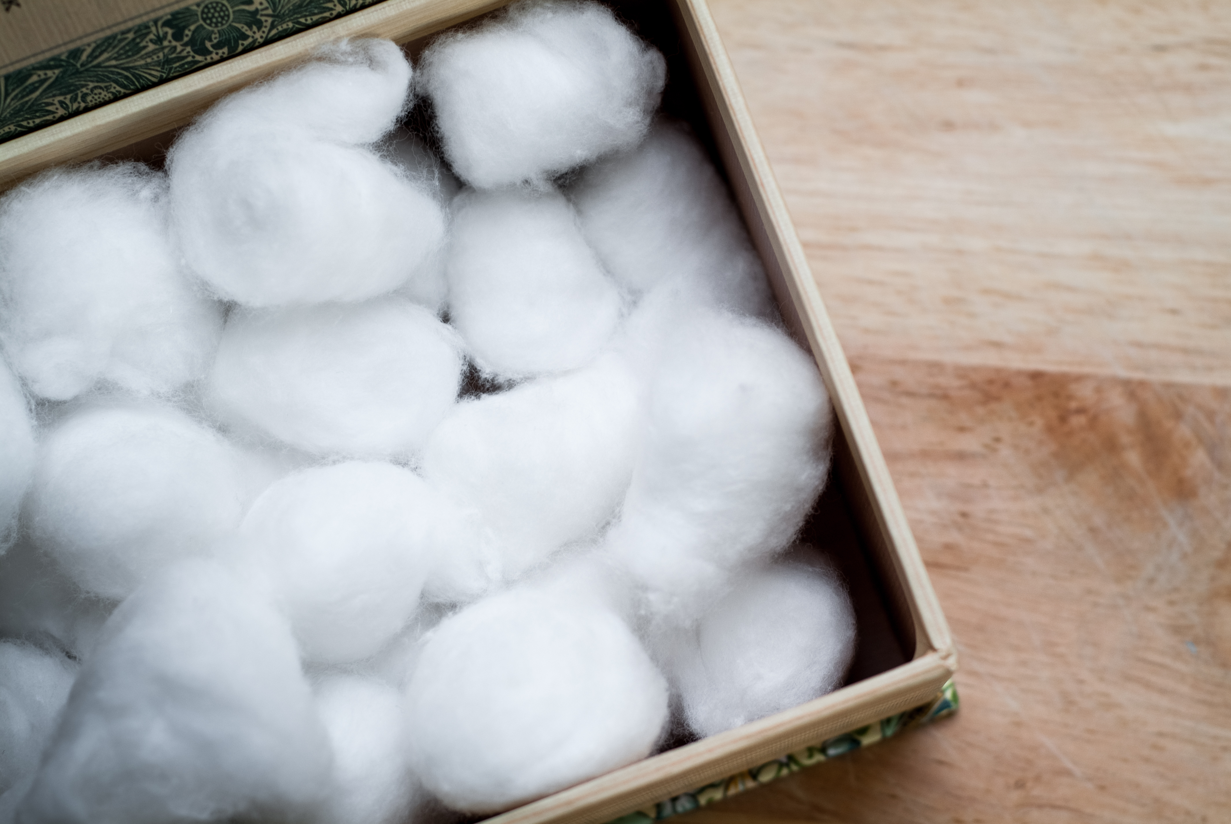 A cardboard box full of white cotton balls