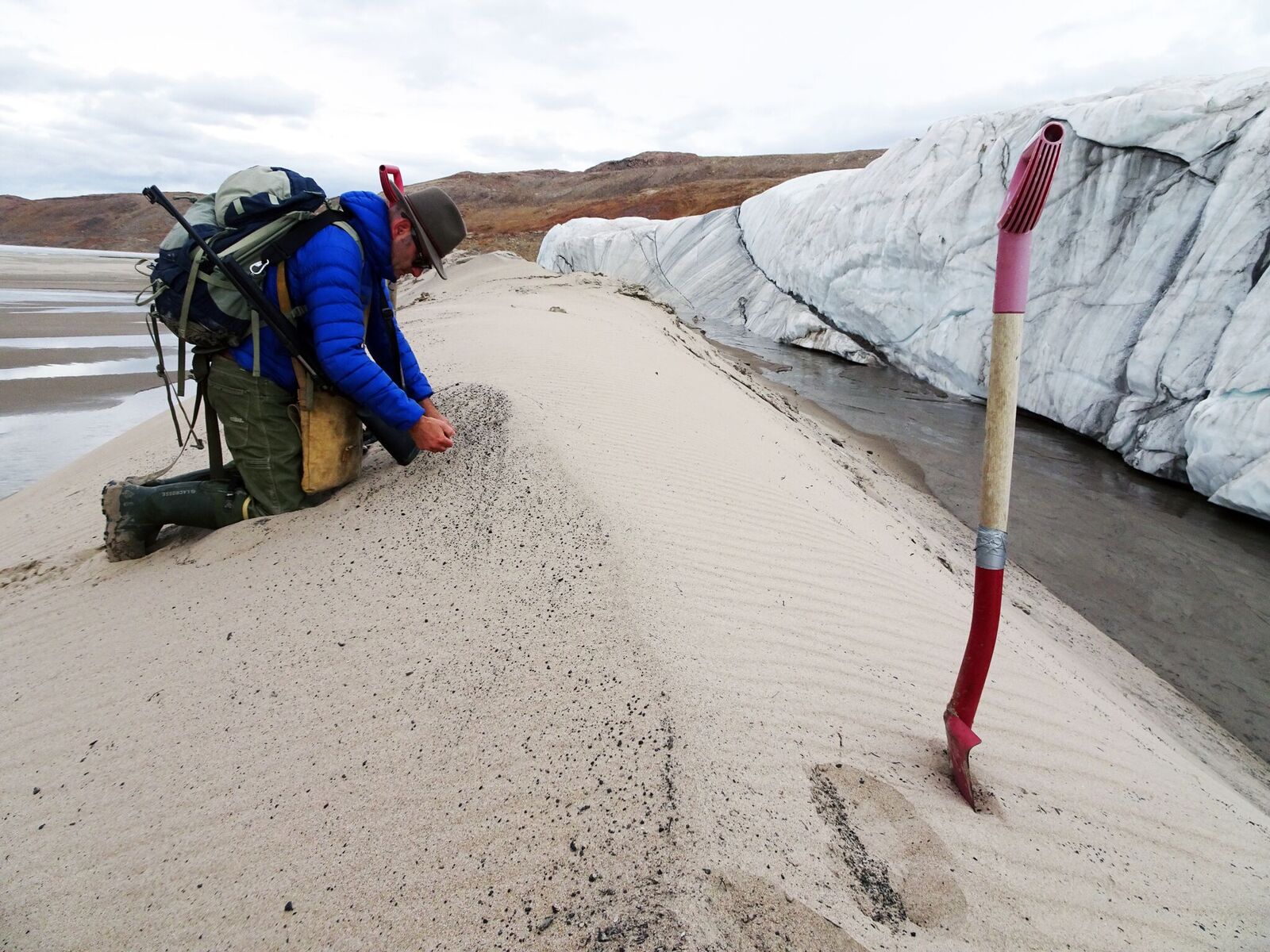 Undated handout photo of Kurt Kjær collecting  sand samples at the  front of Hiawatha Glacier. Copyright Svend  Funder