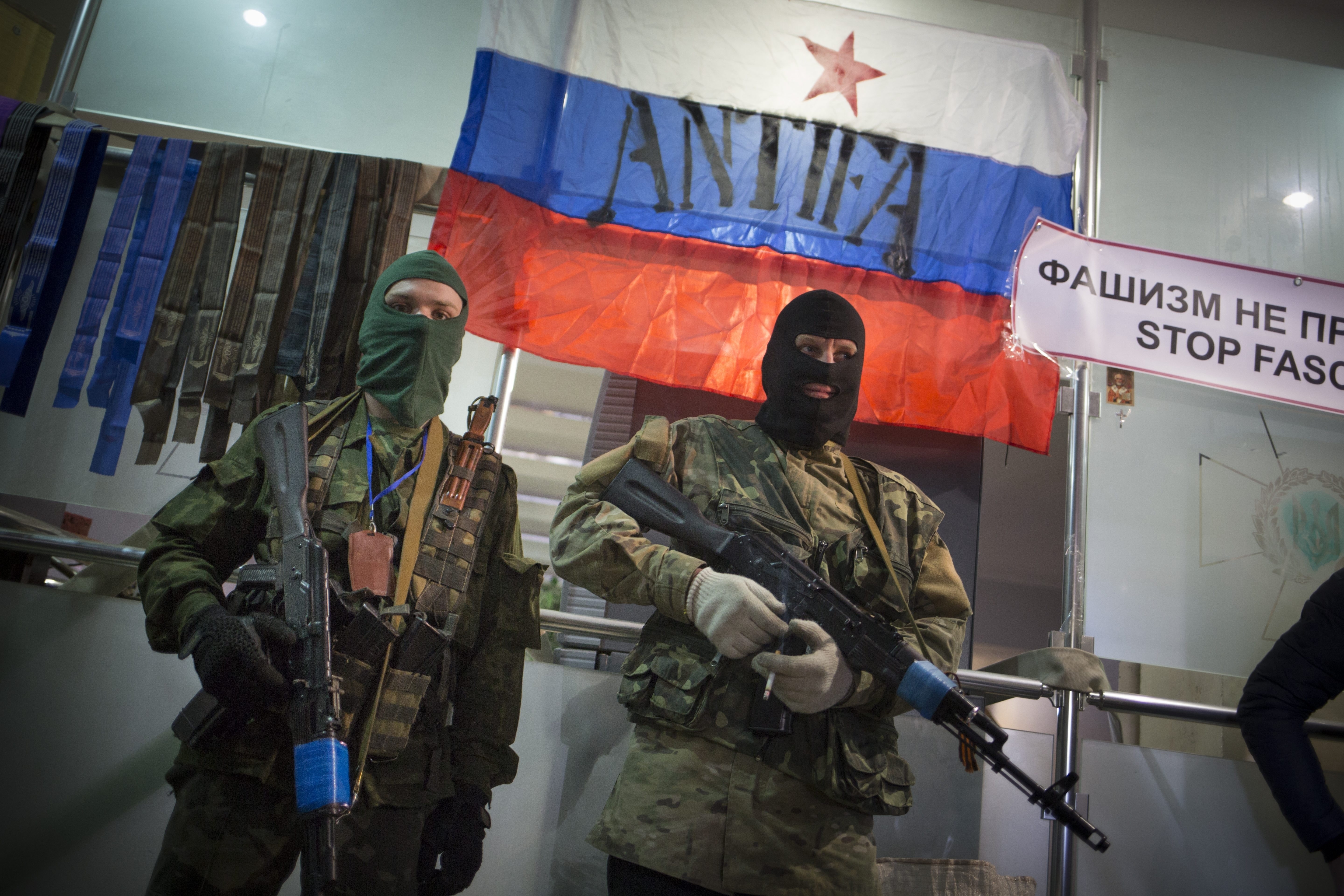 Masked pro-Russian gunmen guard an entrance of the Ukrainian regional office of the Security Service in Luhansk in 2014