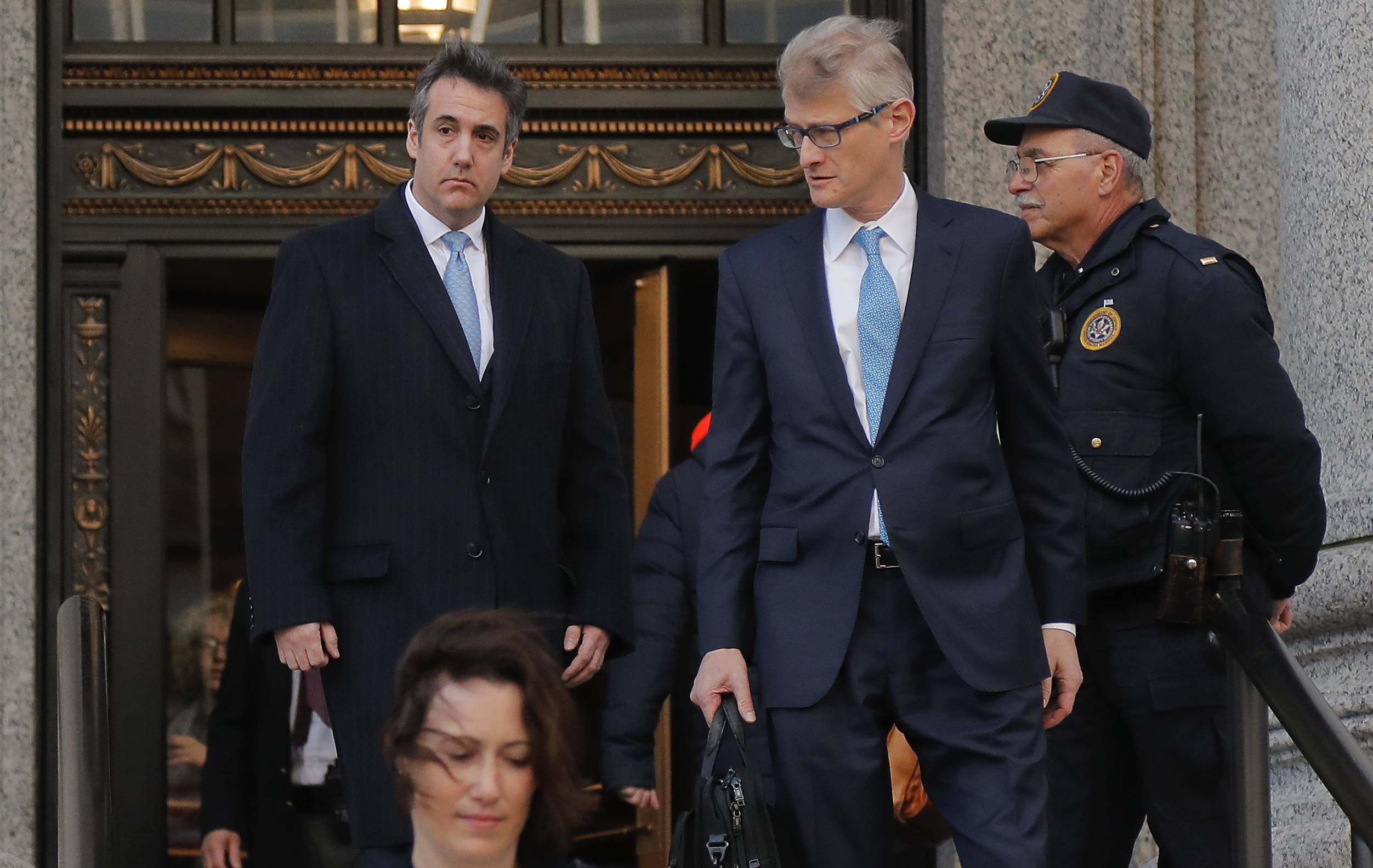 Michael Cohen, left, walks out of federal court in New York with his lawyer Guy Petrillo