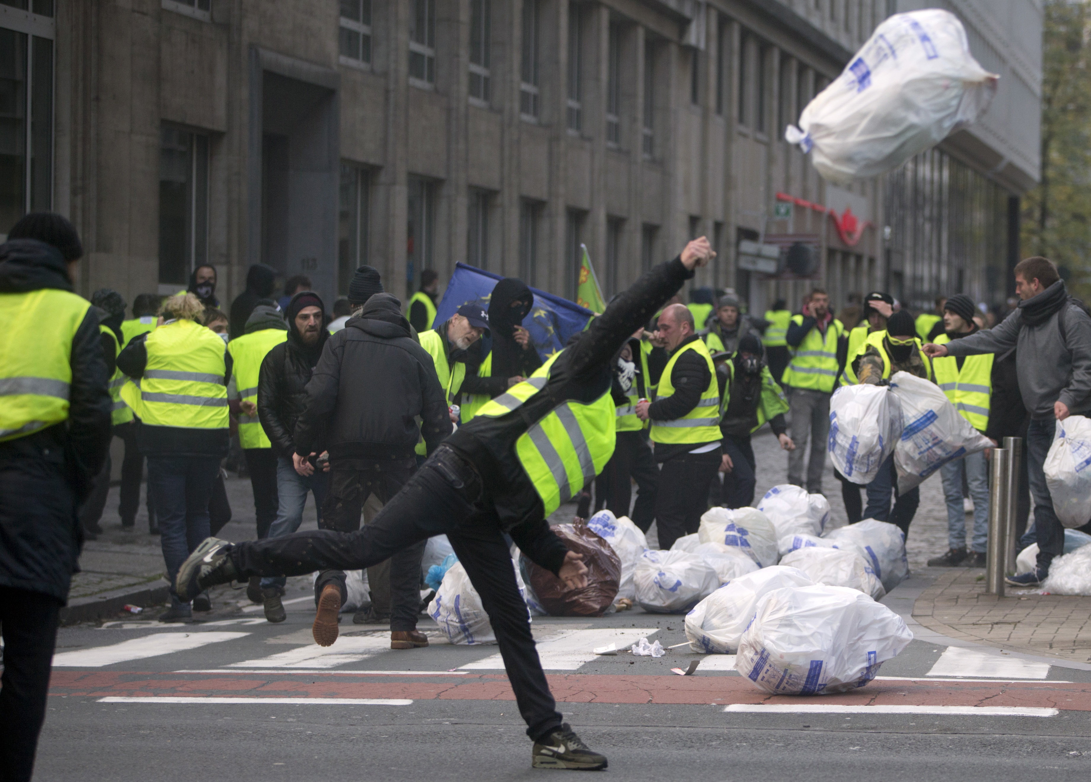 A demonstrator throws a rubbish bag during a protest in Brussels