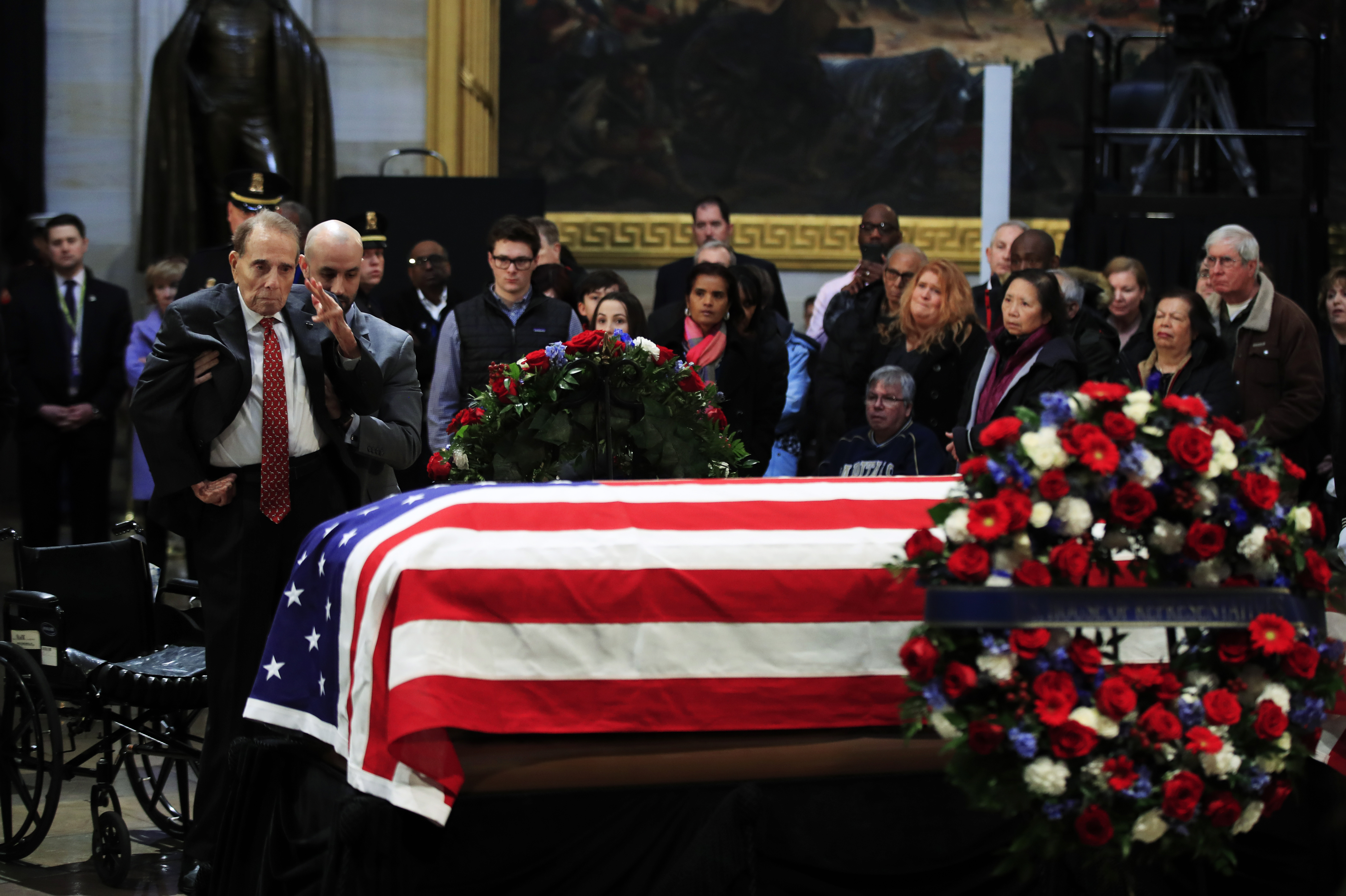 Former senator Bob Dole salutes the flag-draped coffin of former US president George HW Bush at the US Capitol 