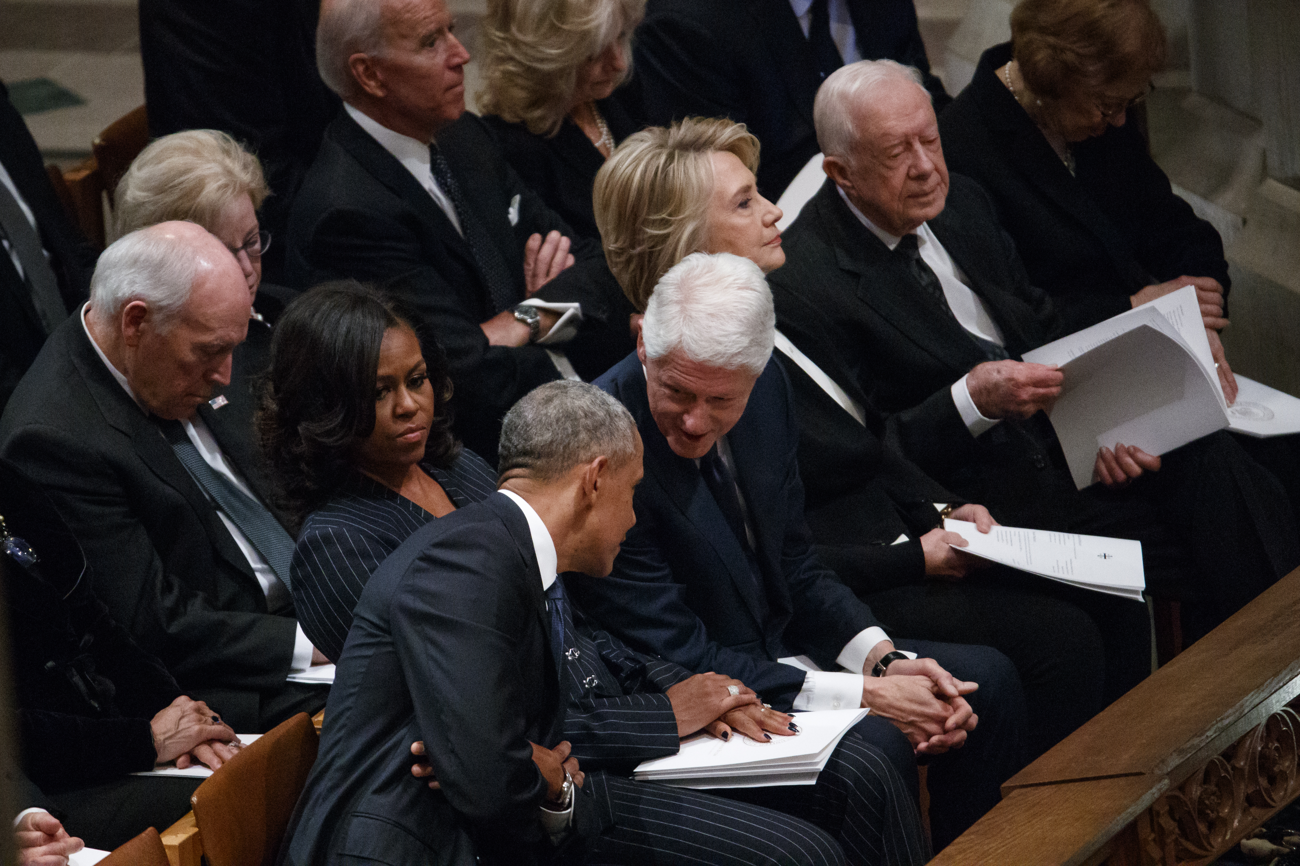 Former President Bill Clinton talks with former President Barack Obama before a State Funeral for former president George HW Bush