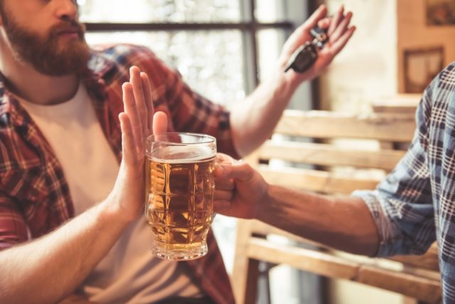 Friends in pub, driver holding back from drinking beer (Thinkstock/PA)