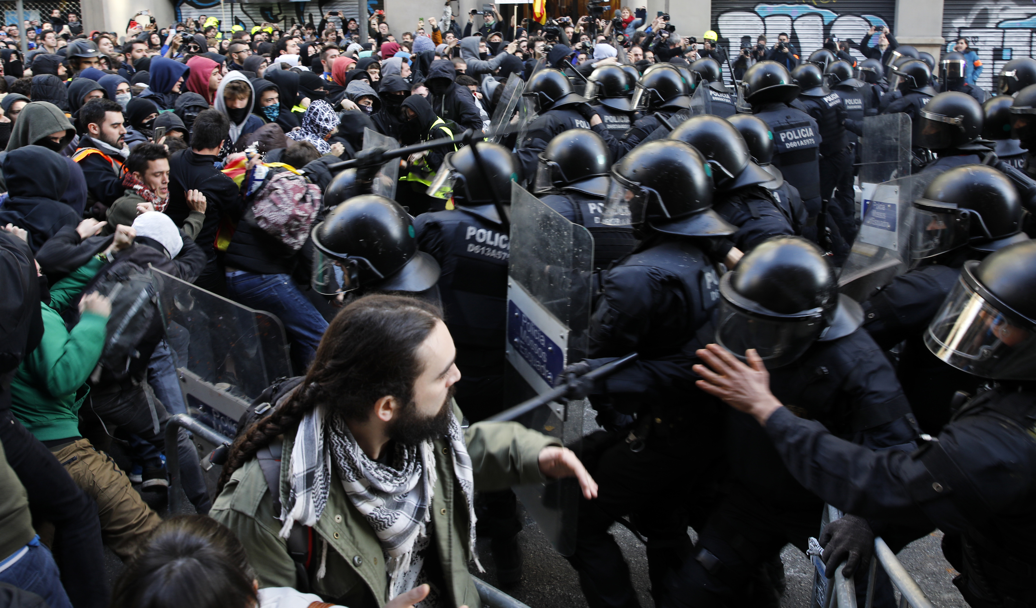 Catalan police prevent demonstrators from approaching the area as they march against Spain's cabinet holding a meeting in Barcelona