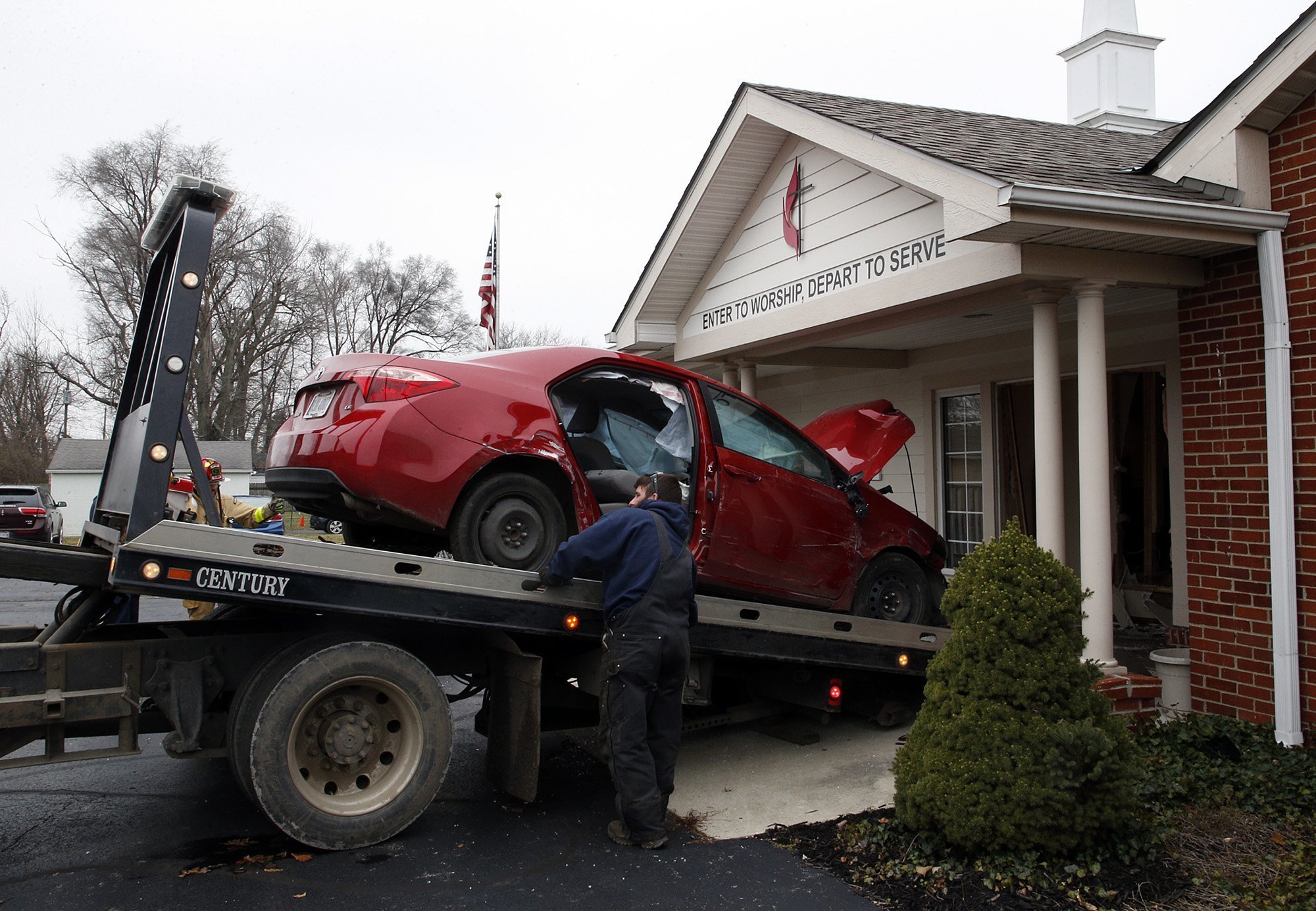 A car that crashed into the entrance of the Crossroads United Methodist Church is towed out of the doorway in Columbus, Ohio