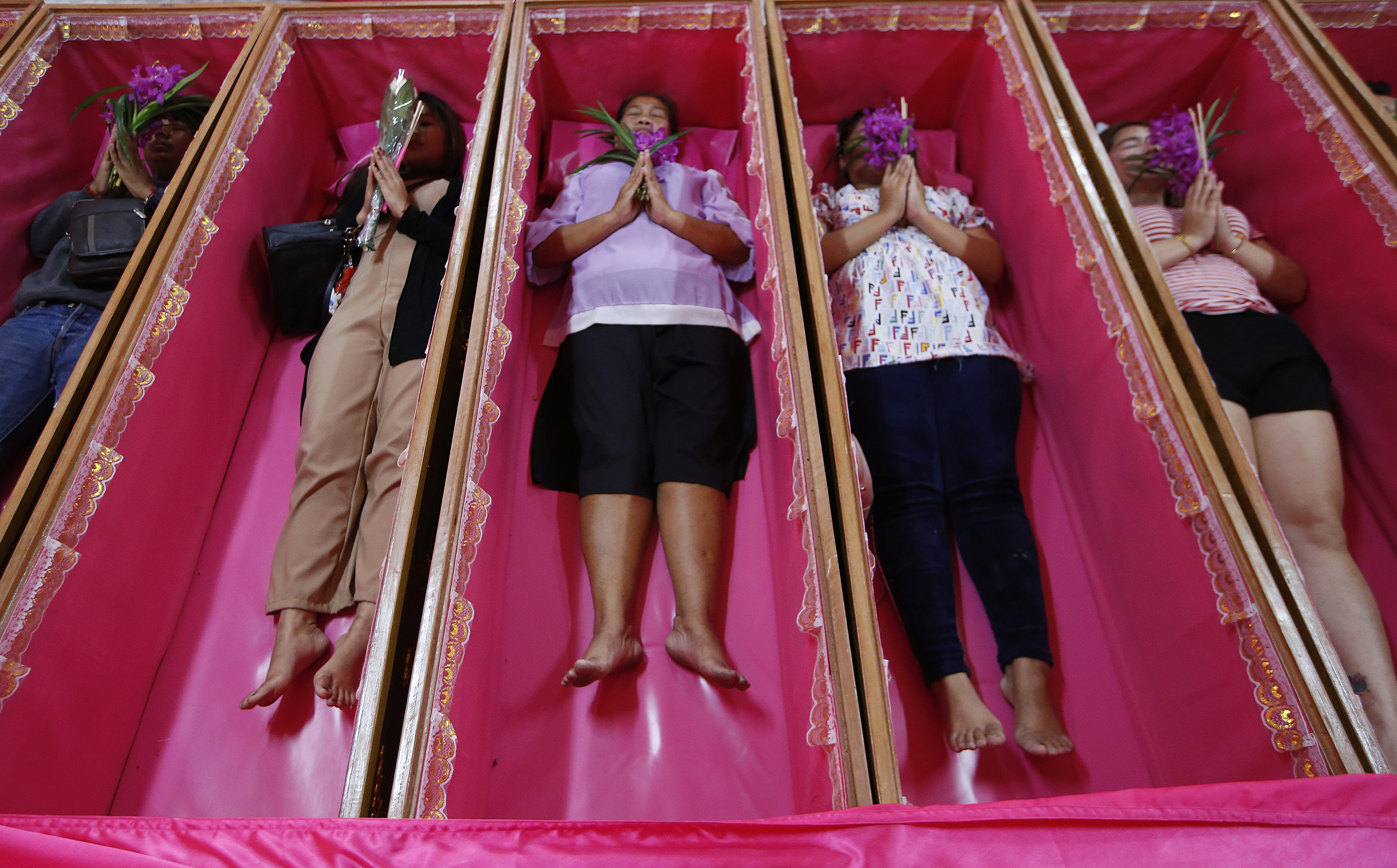 Worshippers pray as they take turns lying in coffins during a ceremony at the Takien temple in suburban Bangkok
