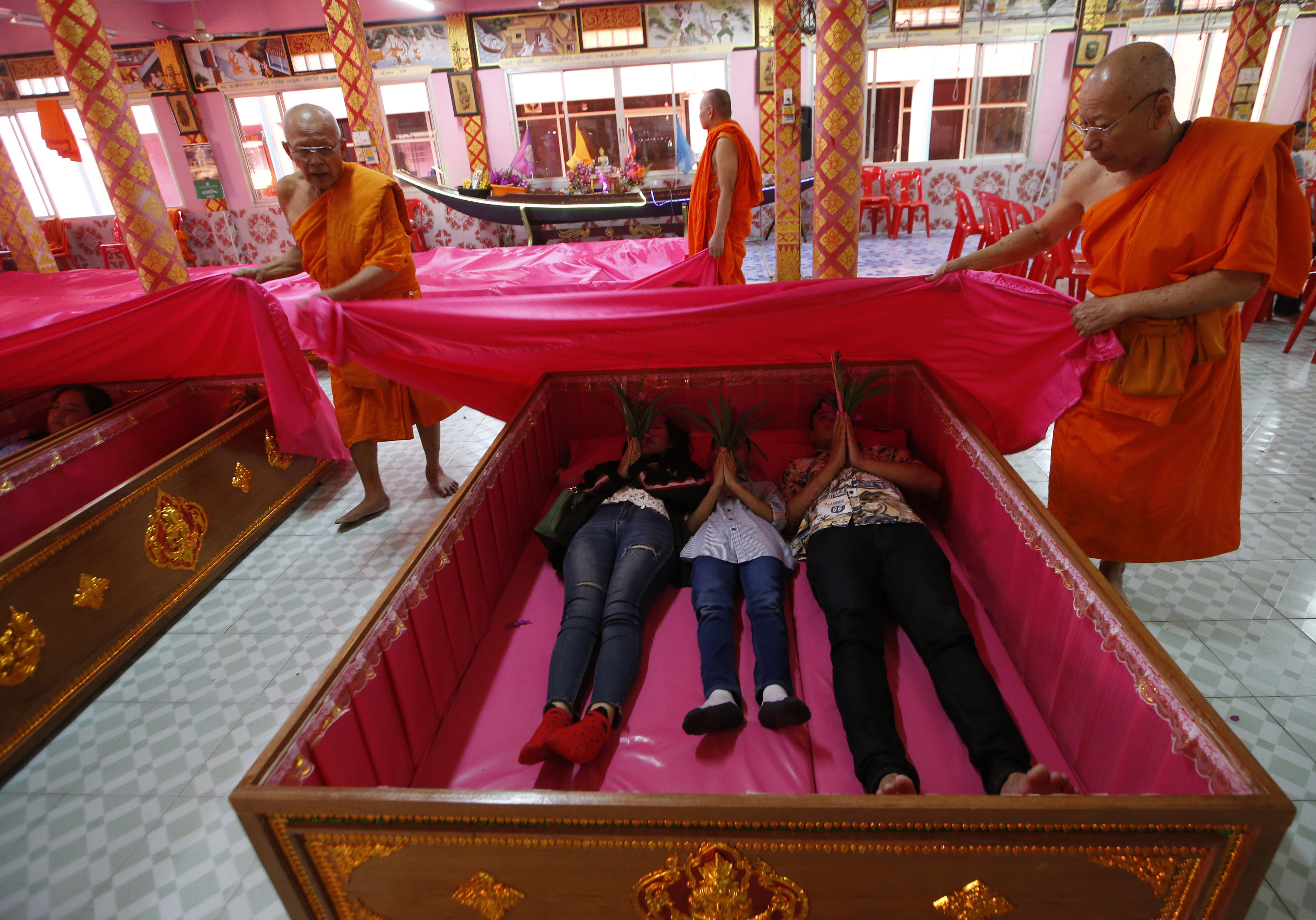 Monks cover worshippers lying in coffins