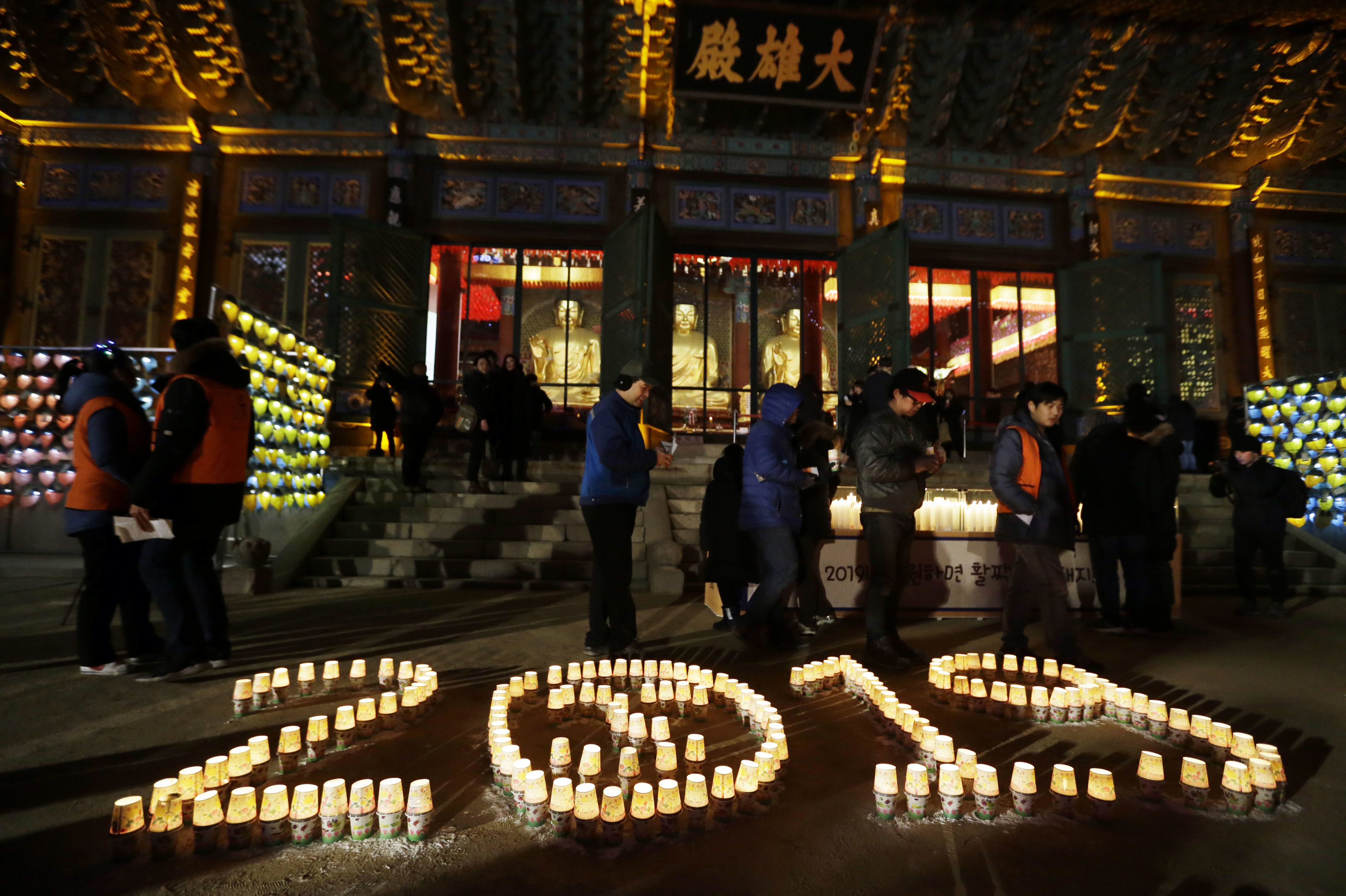 Buddhists light candles during New Year celebrations at Jogyesa Buddhist temple in Seoul