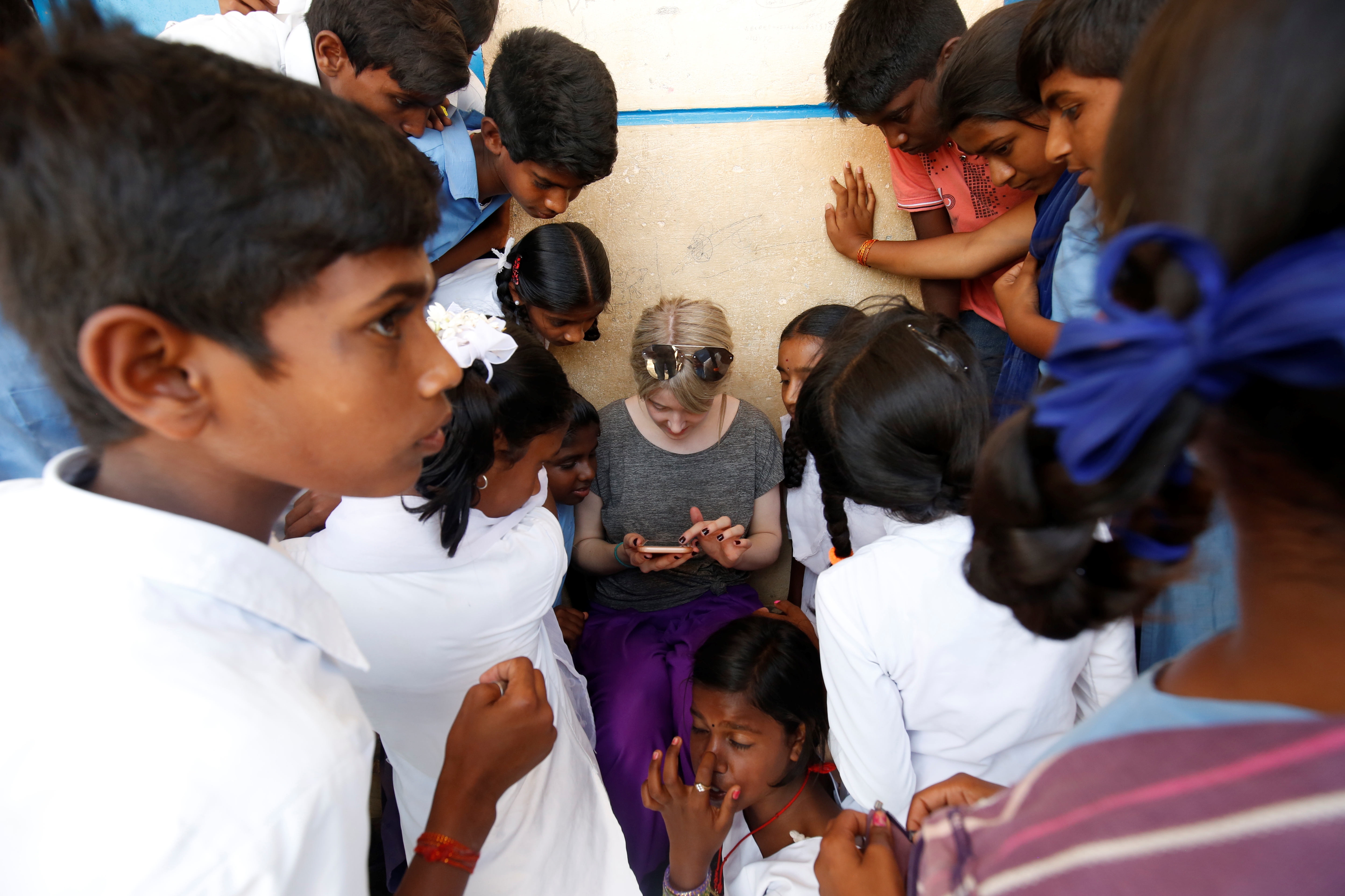 Children crowd round a volunteer